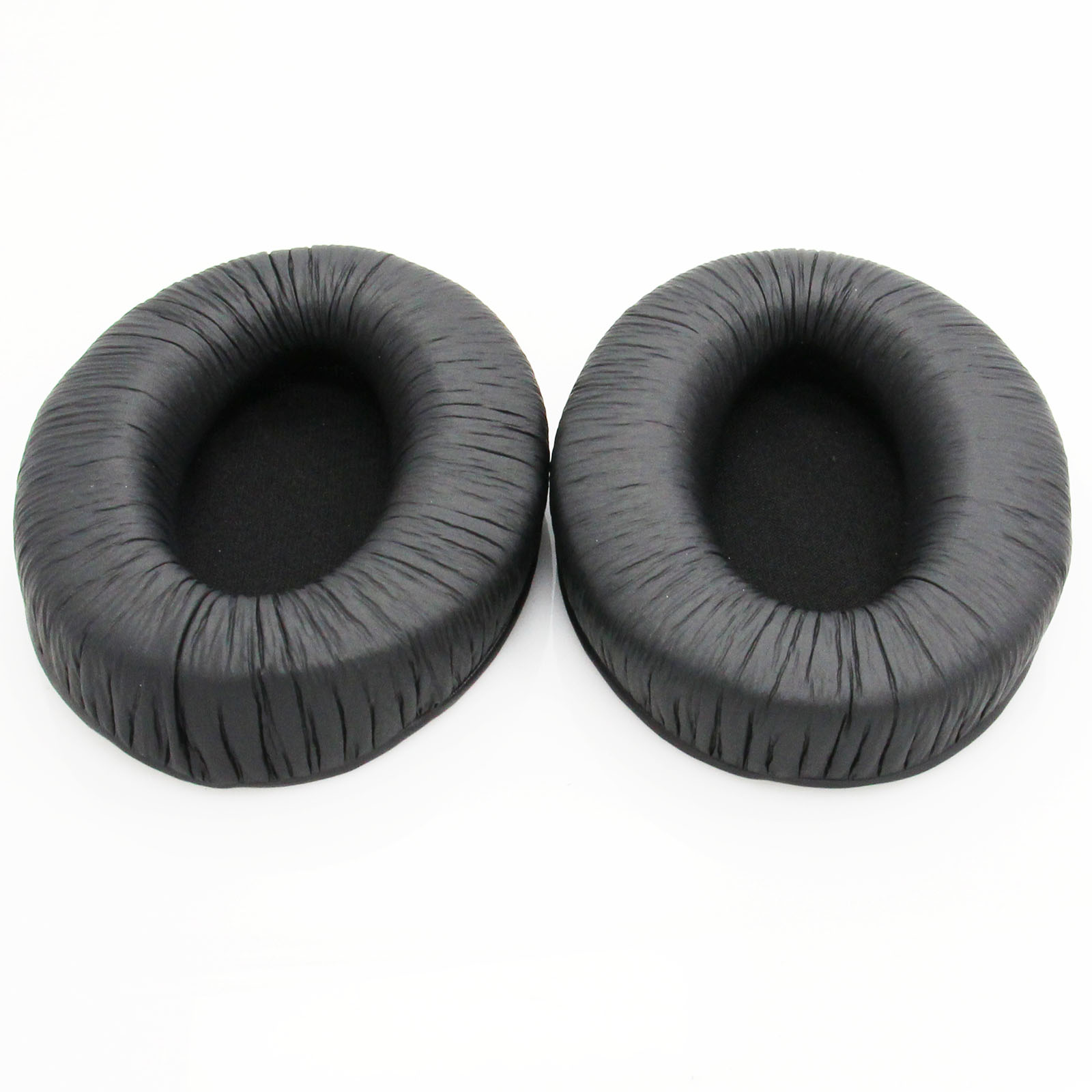 Deux coussinets d'oreille noirs pour casque, côte à côte sur une surface blanche.