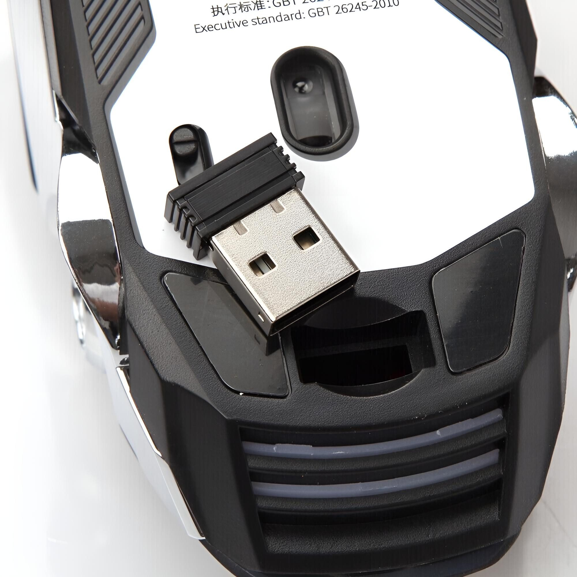 Eine Maus mit USB-Empfänger in ihrem Fach. Die Maus ist schwarz und silber.