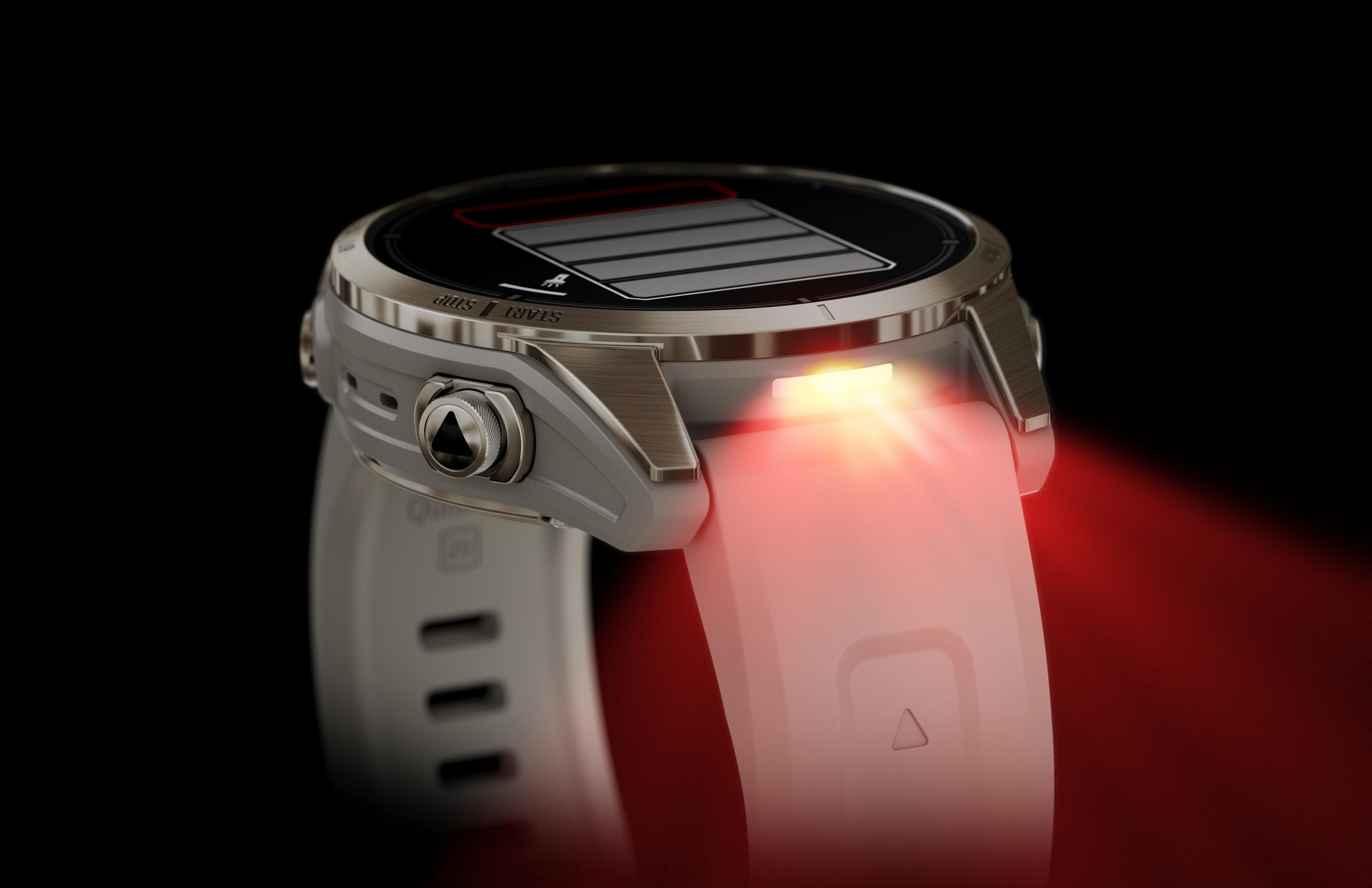 Srebrny i biały smartwatch z czerwonym światłem emitowanym z boku, na czarnym tle.