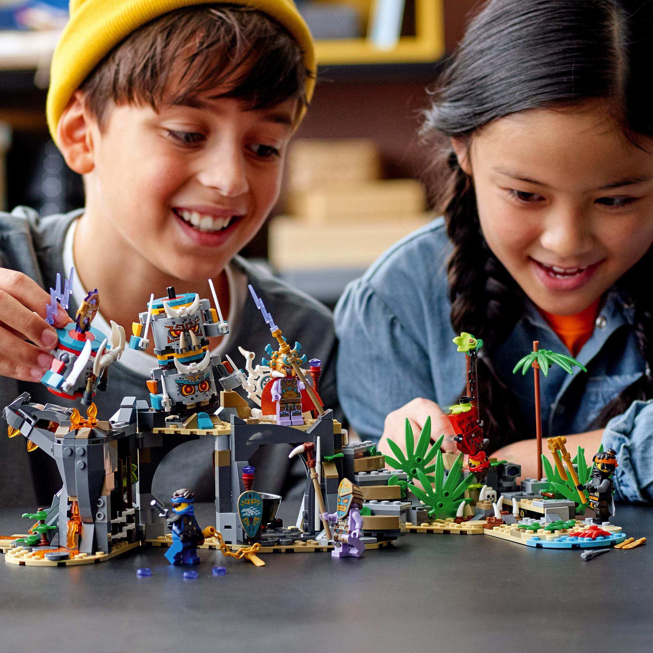 Zwei Kinder spielen mit einem bunten Lego-Set. Lego-Set zeigt eine Kampfszene.
