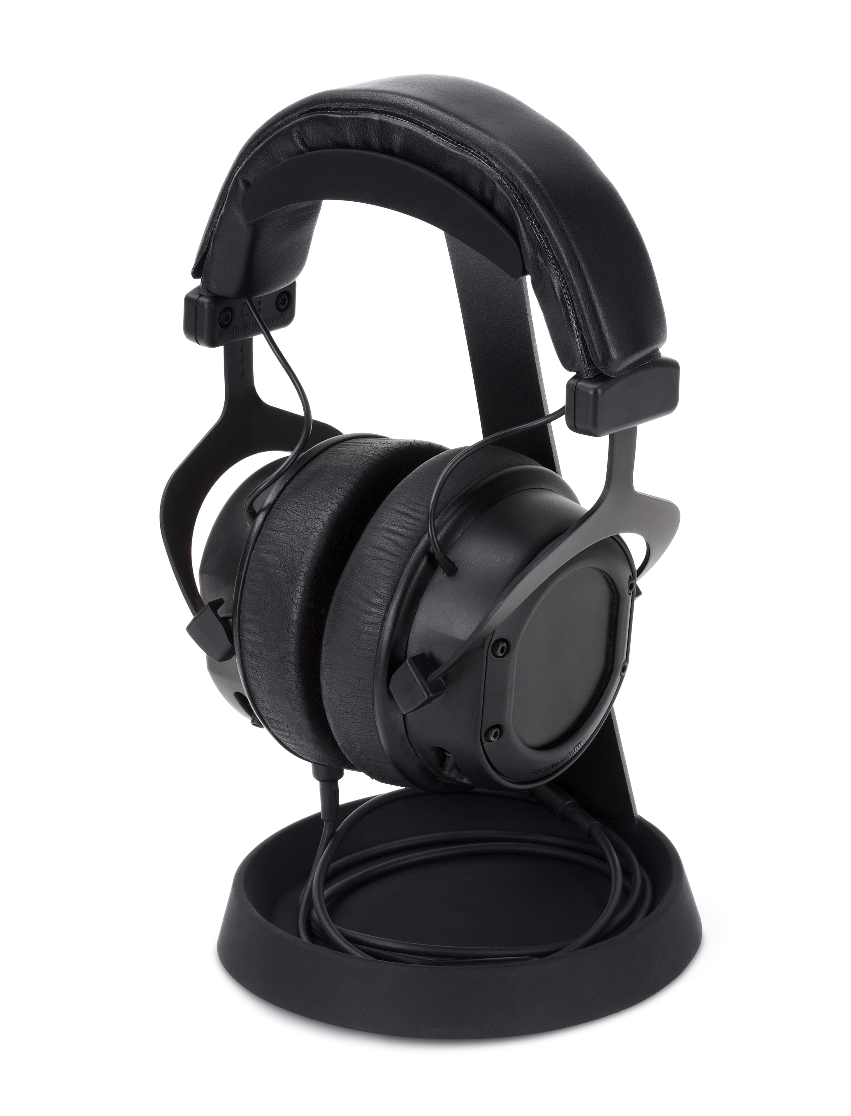 Schwarze Kopfhörer auf einem Ständer. Die Kopfhörer sind Over-Ear-Stil und der Ständer hat eine geschwungene Form.