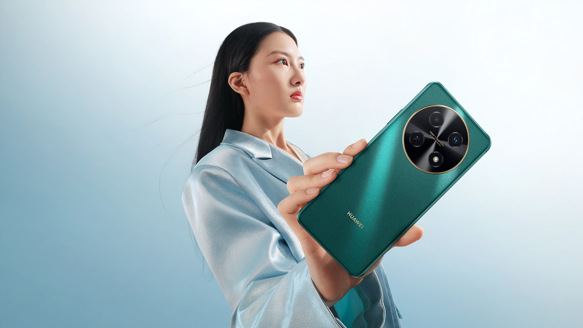 Kobieta trzymająca zielony telefon Huawei z dużym modułem kamery, niebieskie tło.