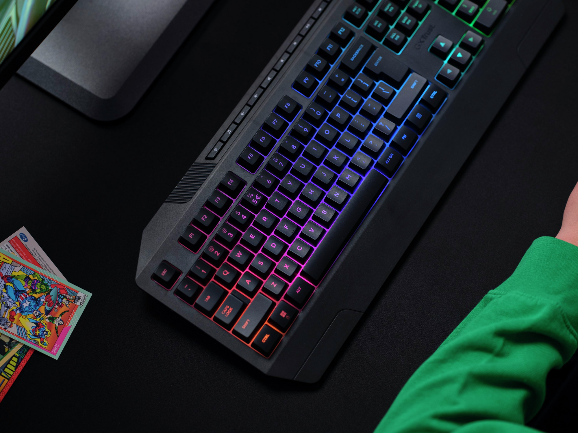 Podświetlana klawiatura dla graczy z klawiszami RGB. Karty na stole. Czarna powierzchnia.