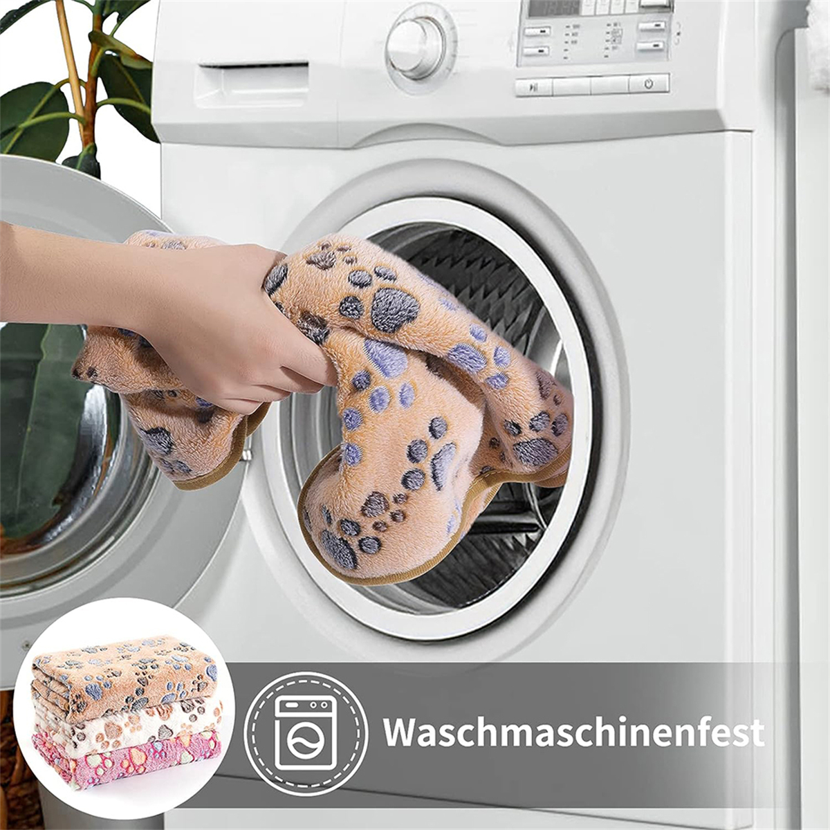 Hand, die ein Handtuch in die Waschmaschine legt.