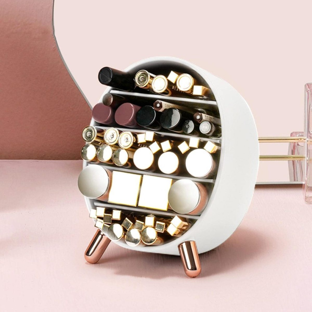 Weißer, runder Make-up-Organizer mit Lippenstiften, Lipgloss und anderen Kosmetika. Goldene Beine.