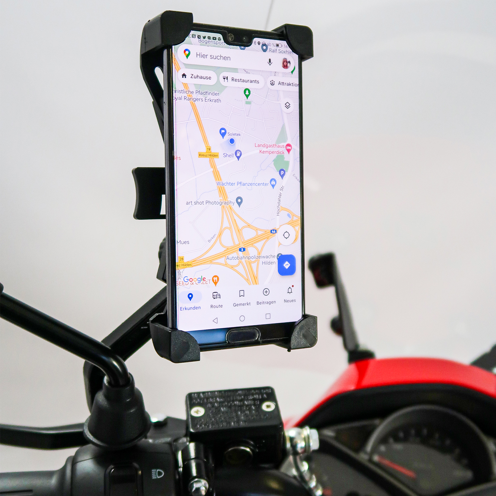 Ein Smartphone an einem Rollerlenker montiert. Das Telefon zeigt eine Karte an. Weißer Hintergrund.