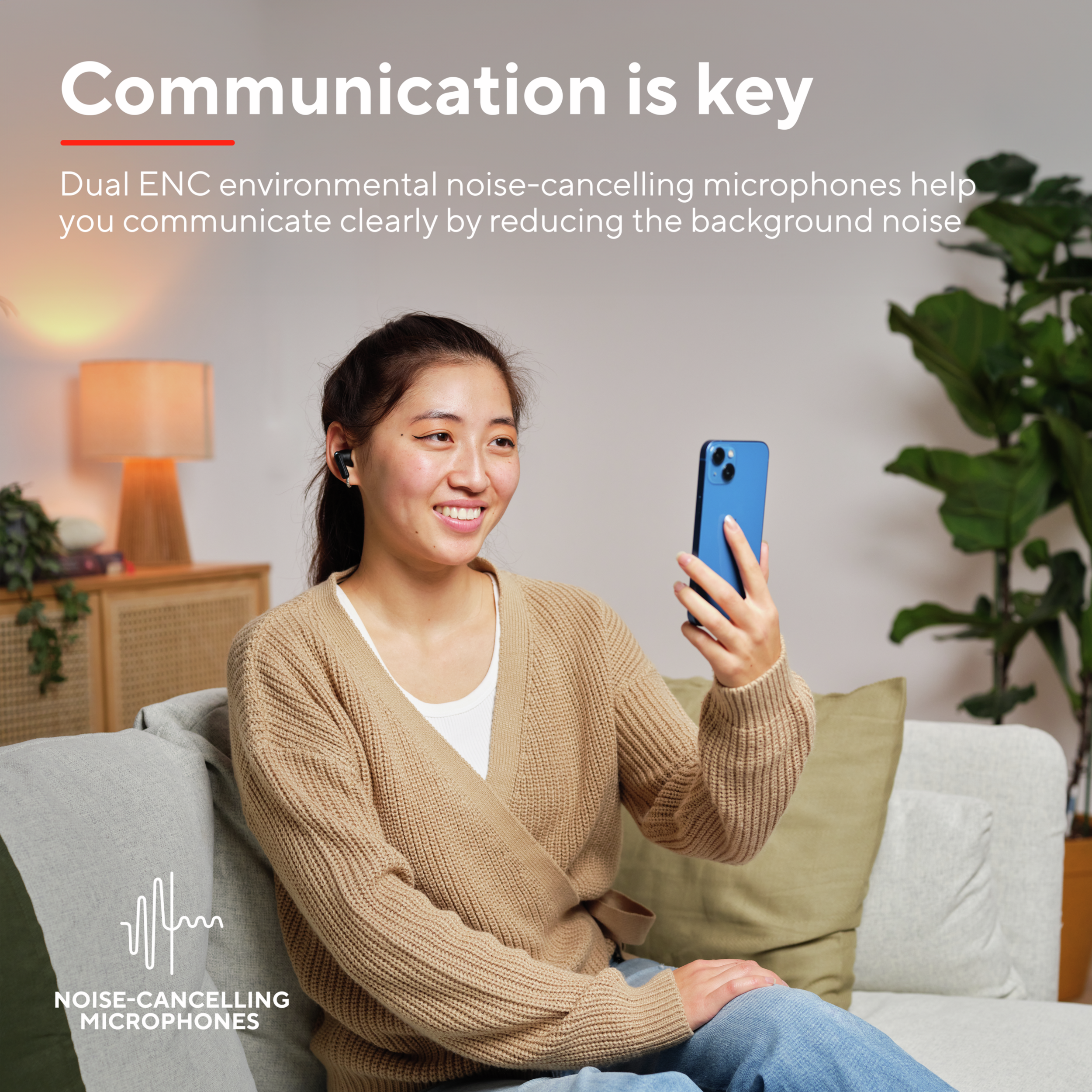 Uśmiechnięta kobieta, używająca słuchawek i telefonu. Tekst: Komunikacja jest kluczem i mikrofony z redukcją szumów.