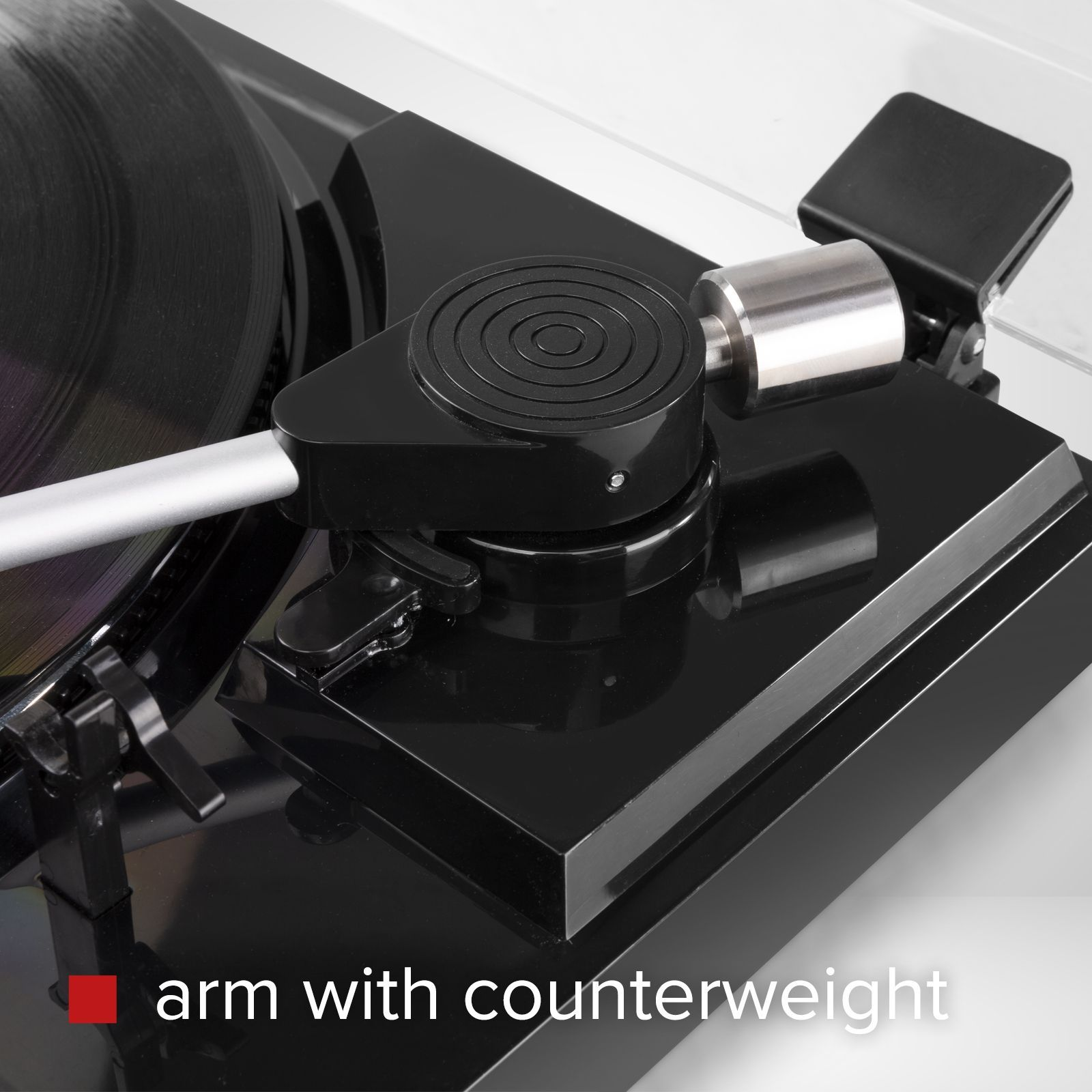 Primer plano de un tocadiscos negro, que muestra el brazo con contrapeso y el disco.