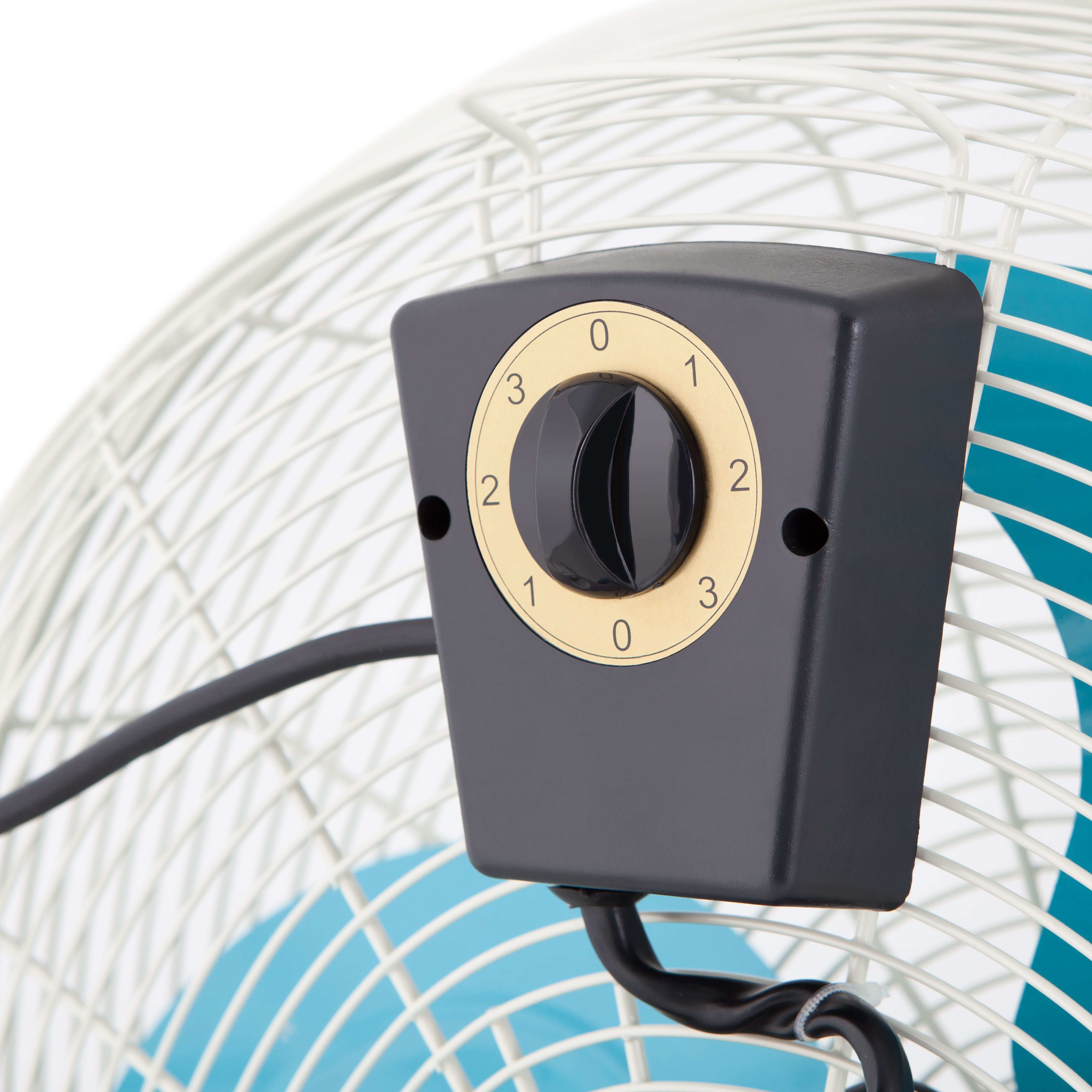 Primer plano del panel de control de un ventilador con un dial numerado 0-3, y un ventilador azul detrás.