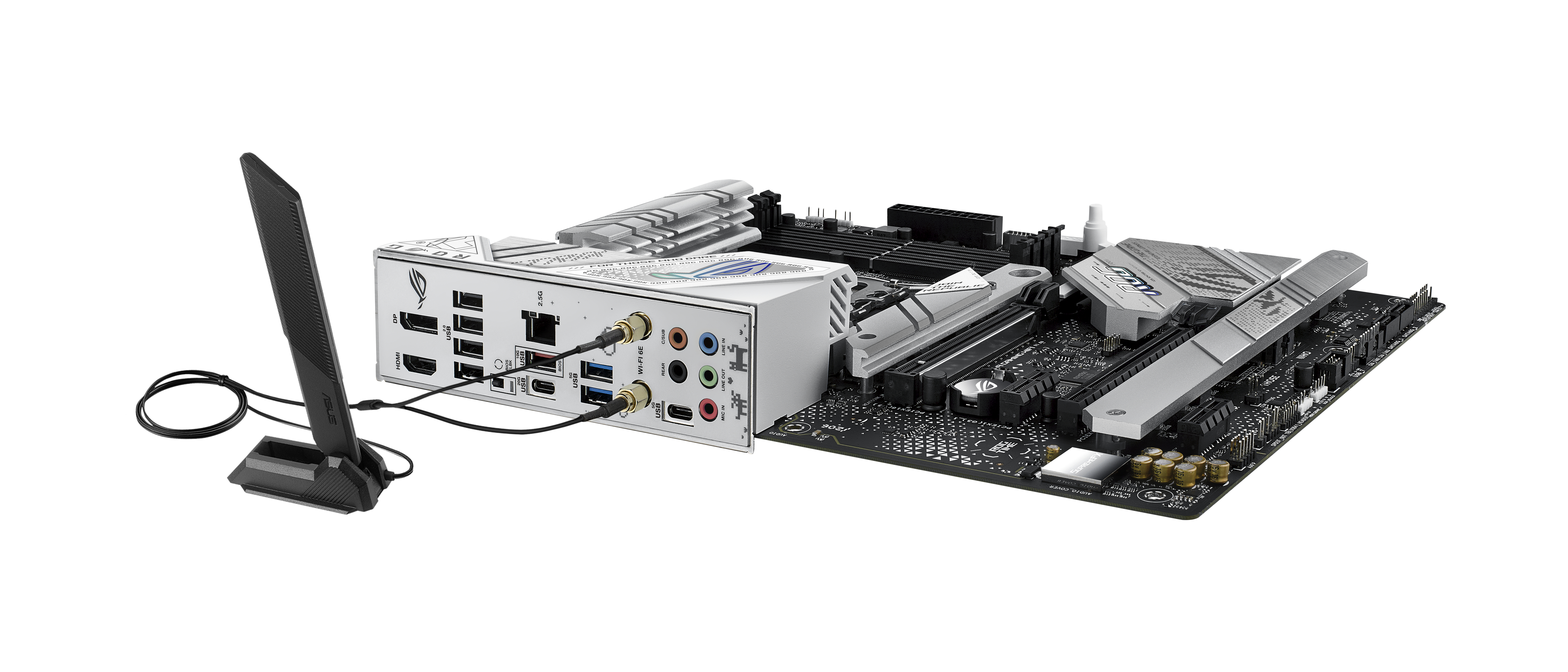 The rear of a motherboard with ports, a wireless antenna and cables, on a white surface.