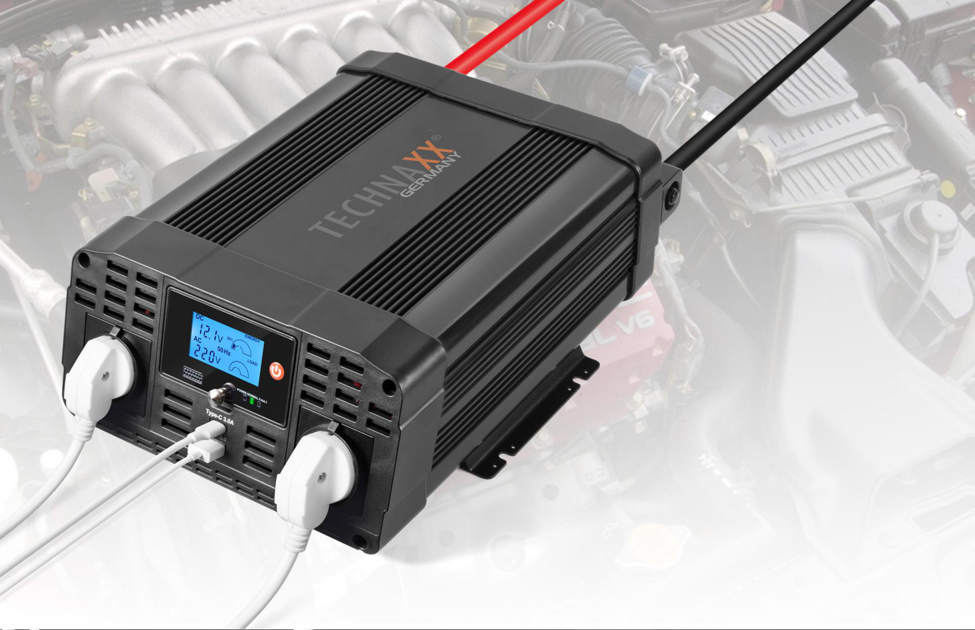 Czarny falownik z wtyczkami, wyświetlacz cyfrowy, tło silnika samochodowego.