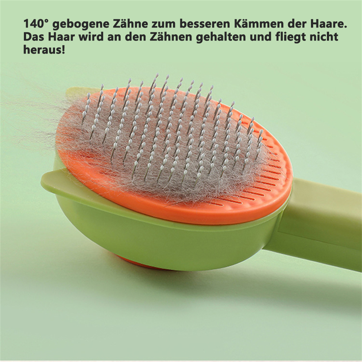 Haustierbürste mit gebogenen Zähnen, entfernt Haare, auf grüner Oberfläche.