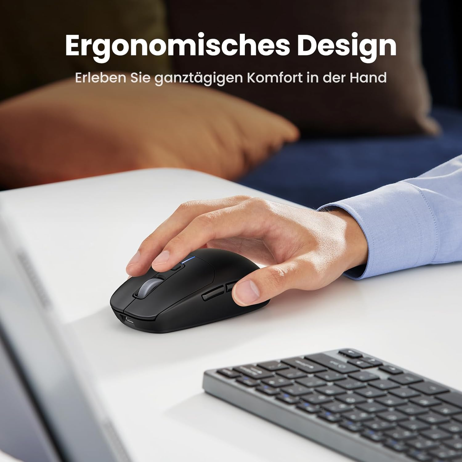 Hand benutzt schwarze Maus auf weißem Schreibtisch, Tastatur daneben, ergonomisch.