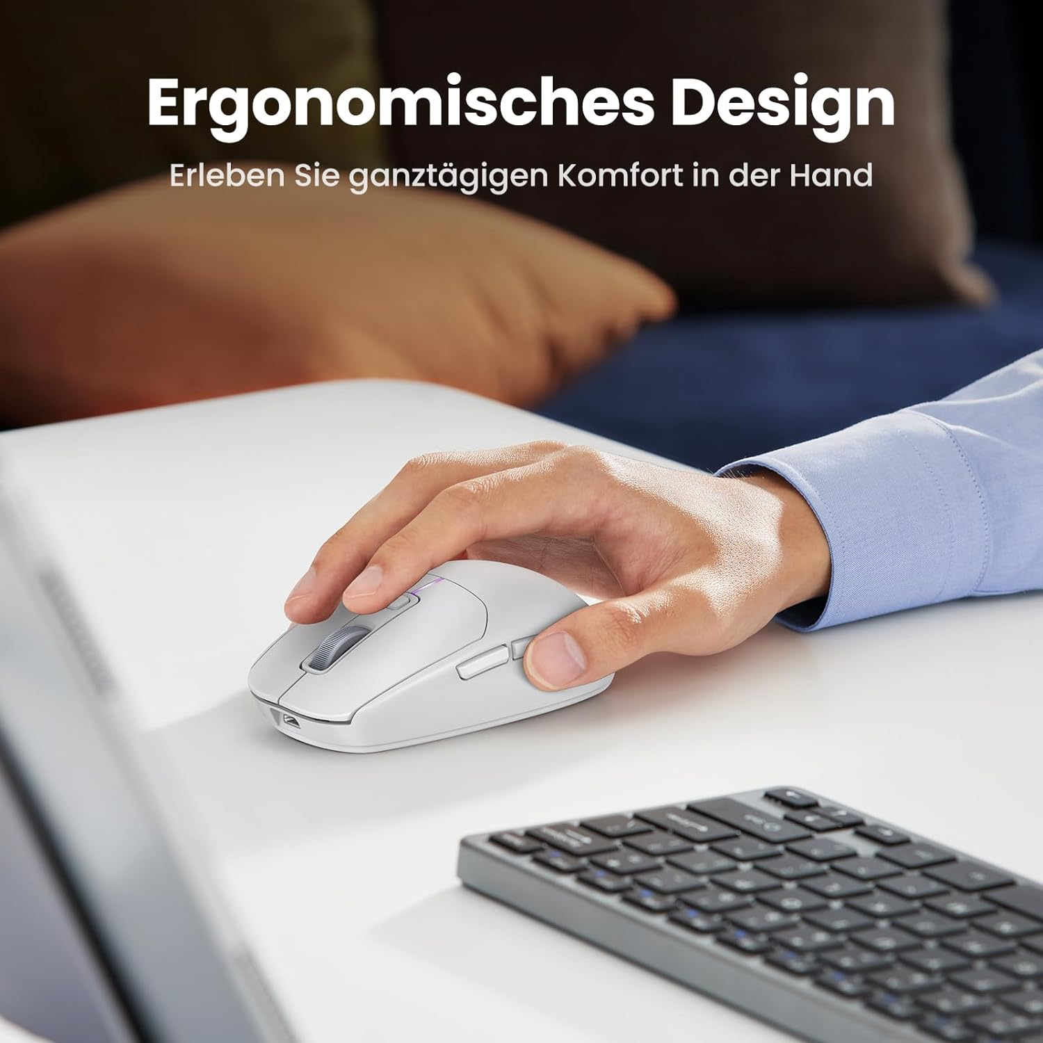 Die Hand einer Person benutzt eine weiße kabellose Maus auf einem weißen Schreibtisch neben einer Tastatur.