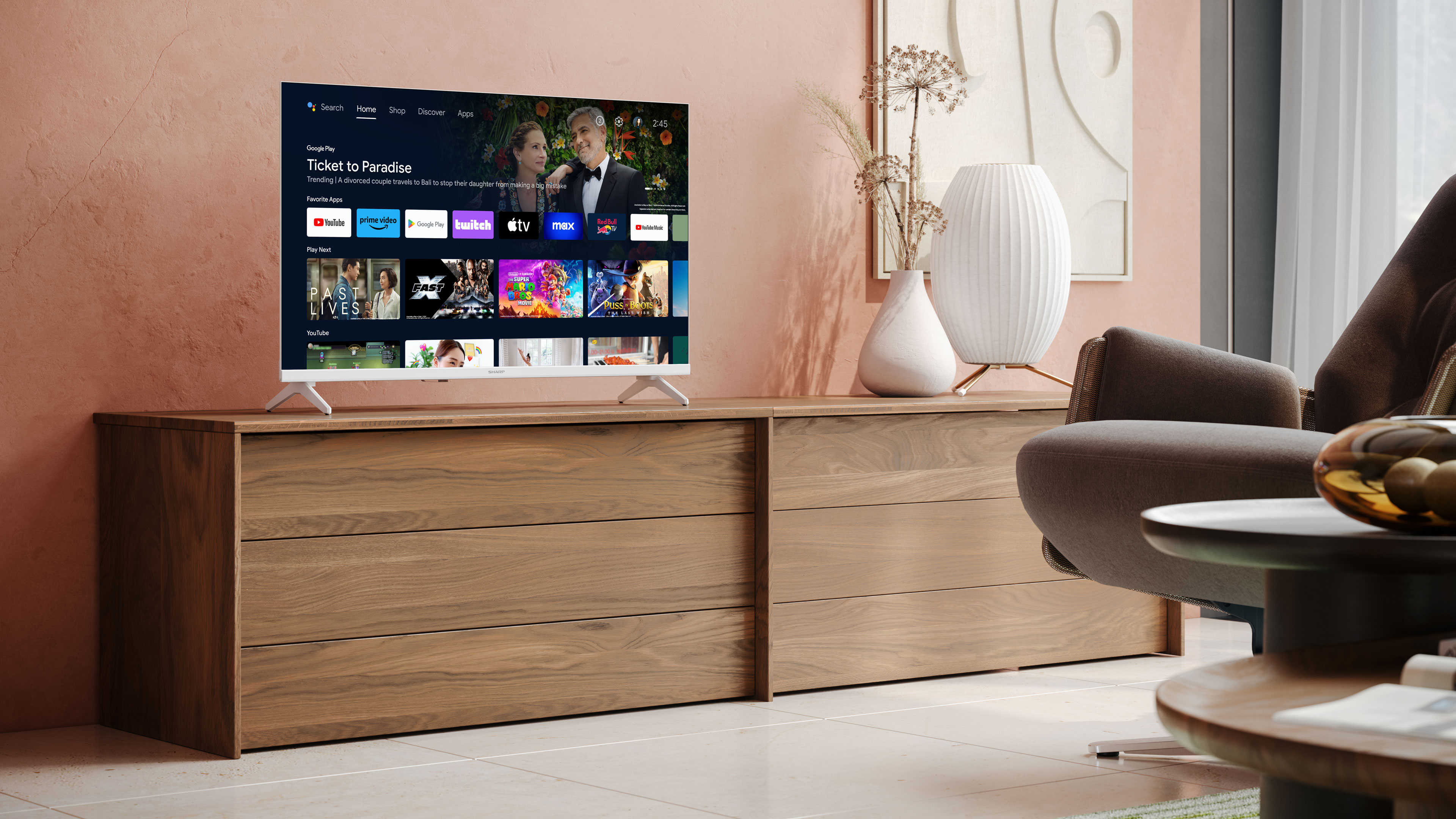 Ein Fernseher, der einen Film auf einer Holzkommode mit einer Vase in einem Wohnzimmer zeigt.