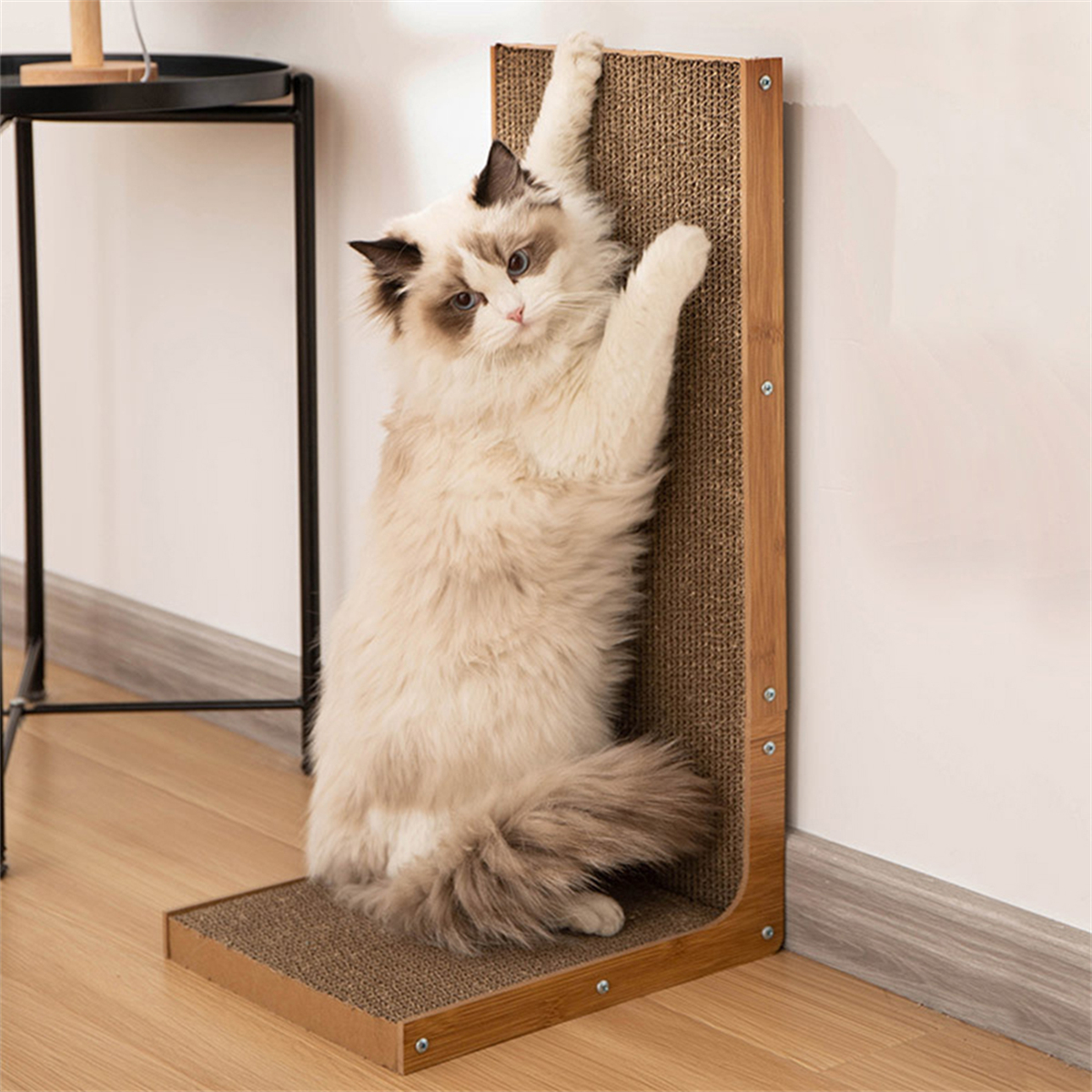 Eine Katze kratzt an einem vertikalen Karton-Kratzbaum, der an einer Wand befestigt ist.