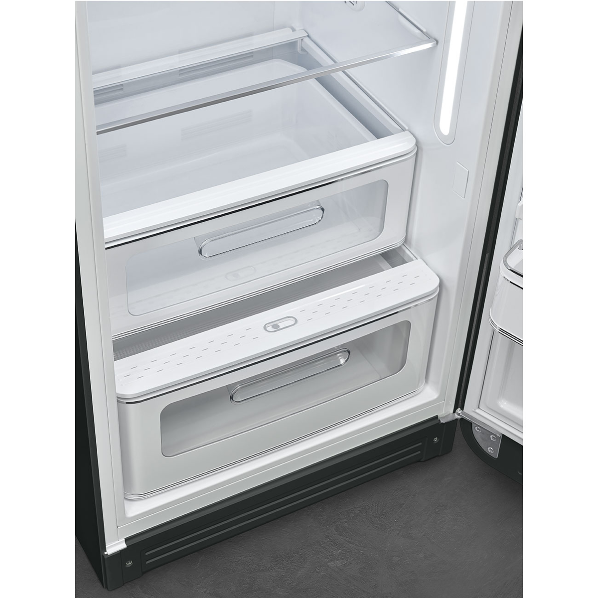 Interior de refrigerador con dos cajones transparentes y un tirador metálico, abierto sobre fondo blanco.