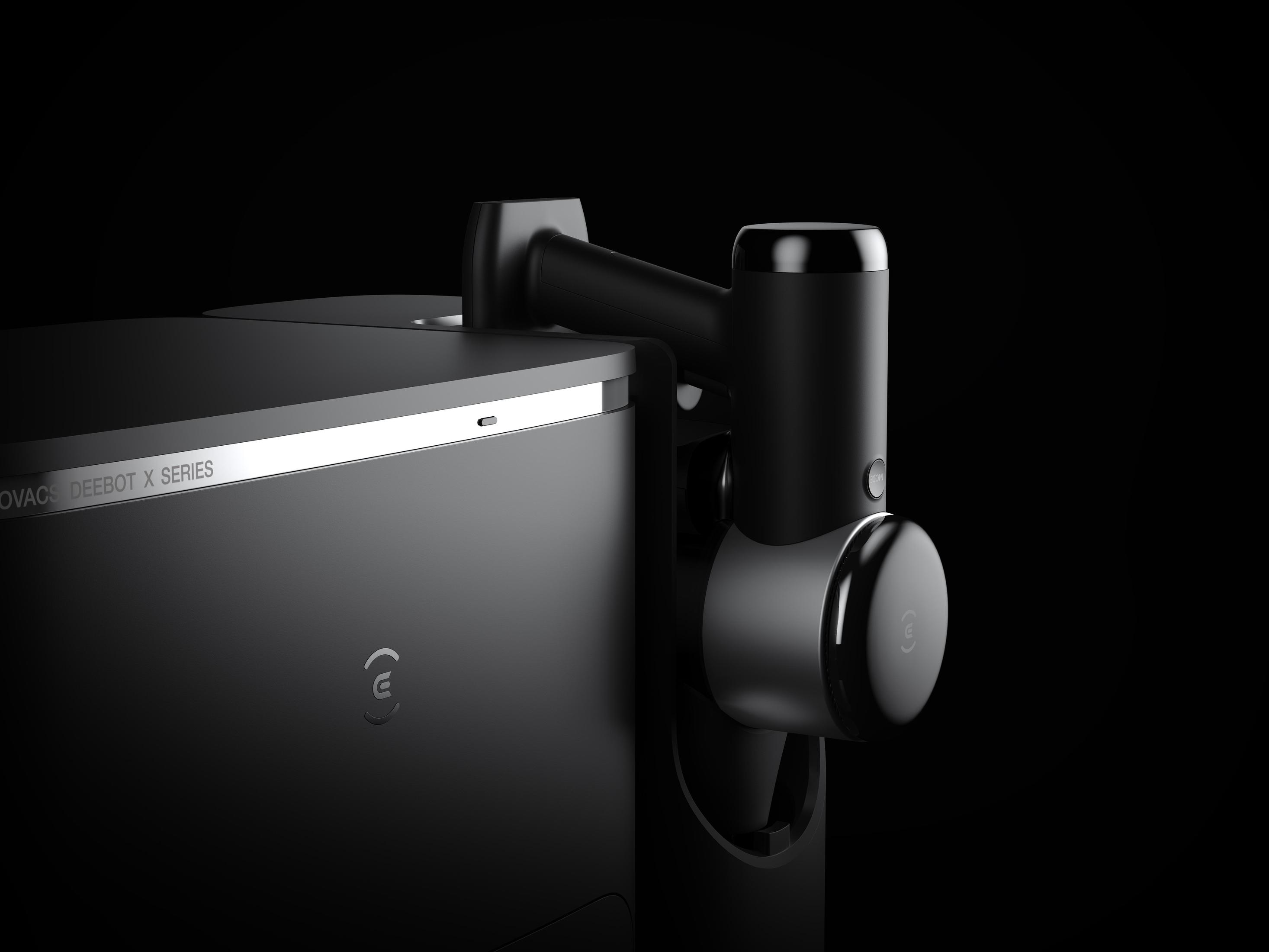 Czarny robot odkurzający ze szczotką boczną i stacją ładującą, na czarnym tle.