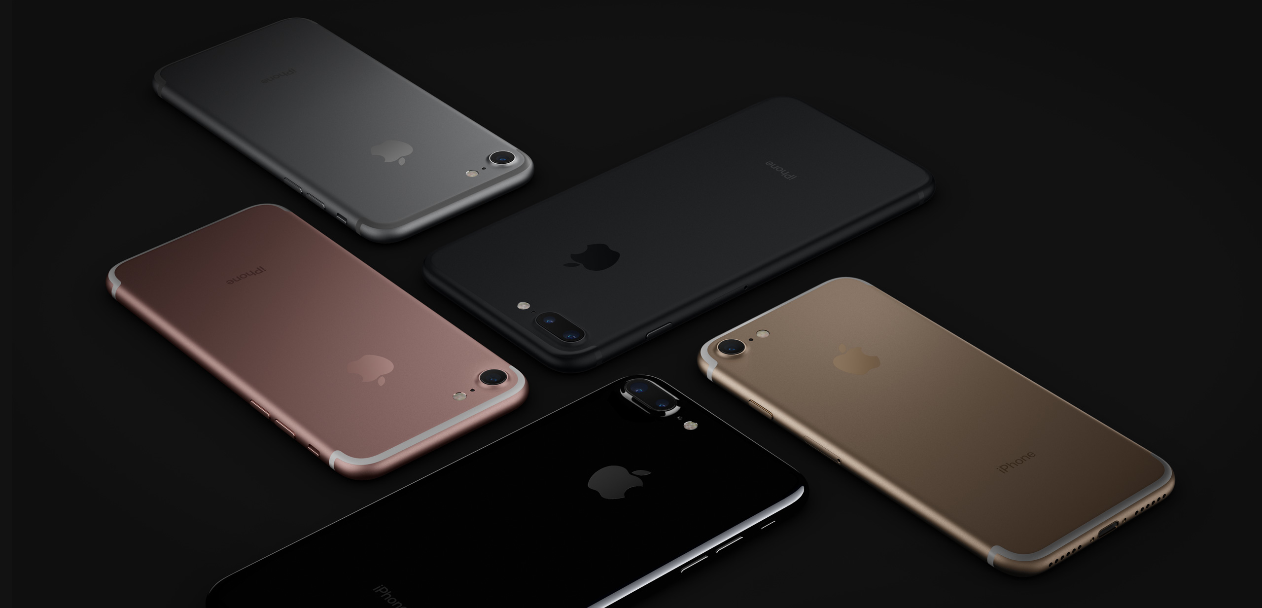 Cinque iPhone in vari colori, disposti su una superficie nera. Ogni telefono mostra il logo Apple.