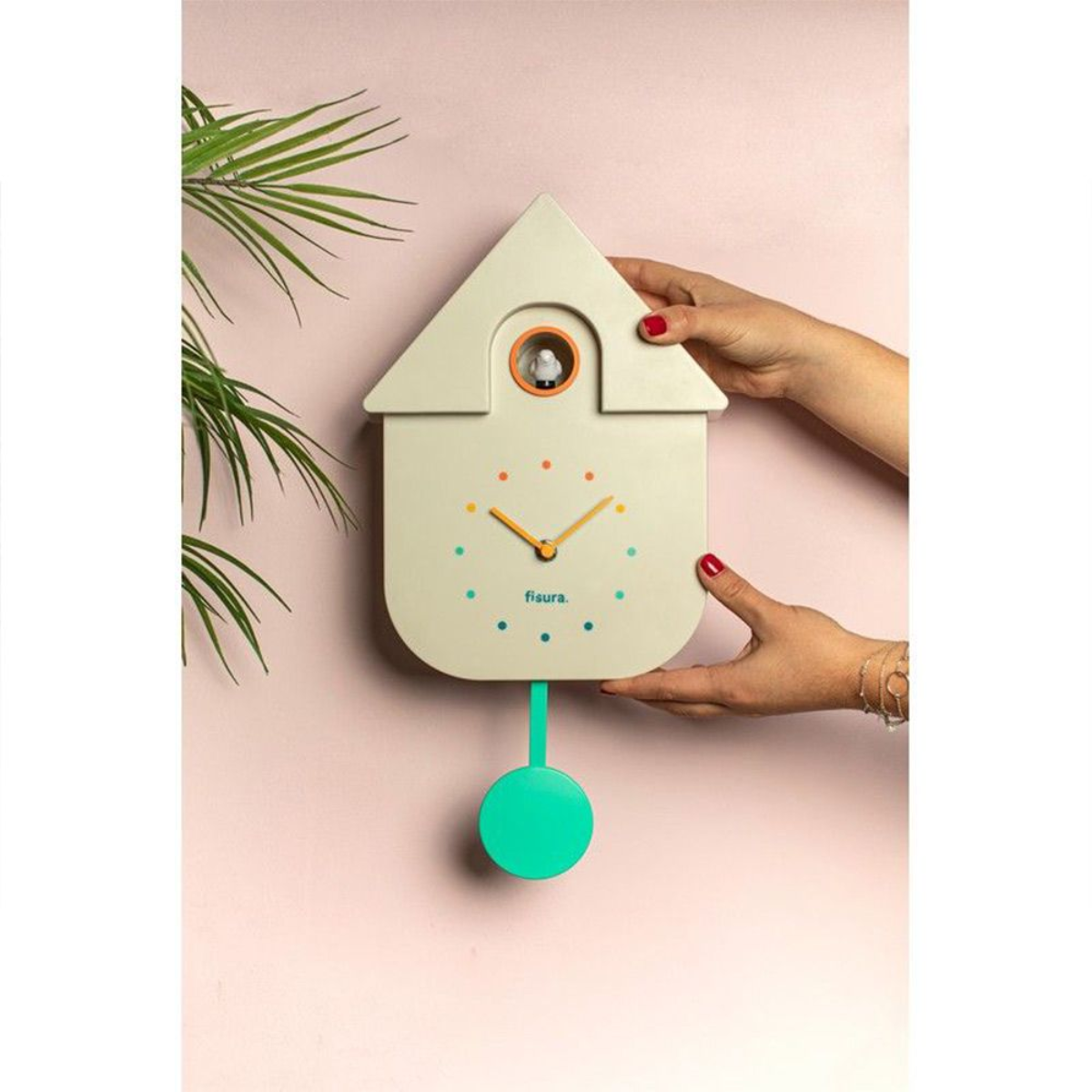Un orologio a cucù a forma di casa, tenuto da due mani. Un uccello è nella finestra circolare.