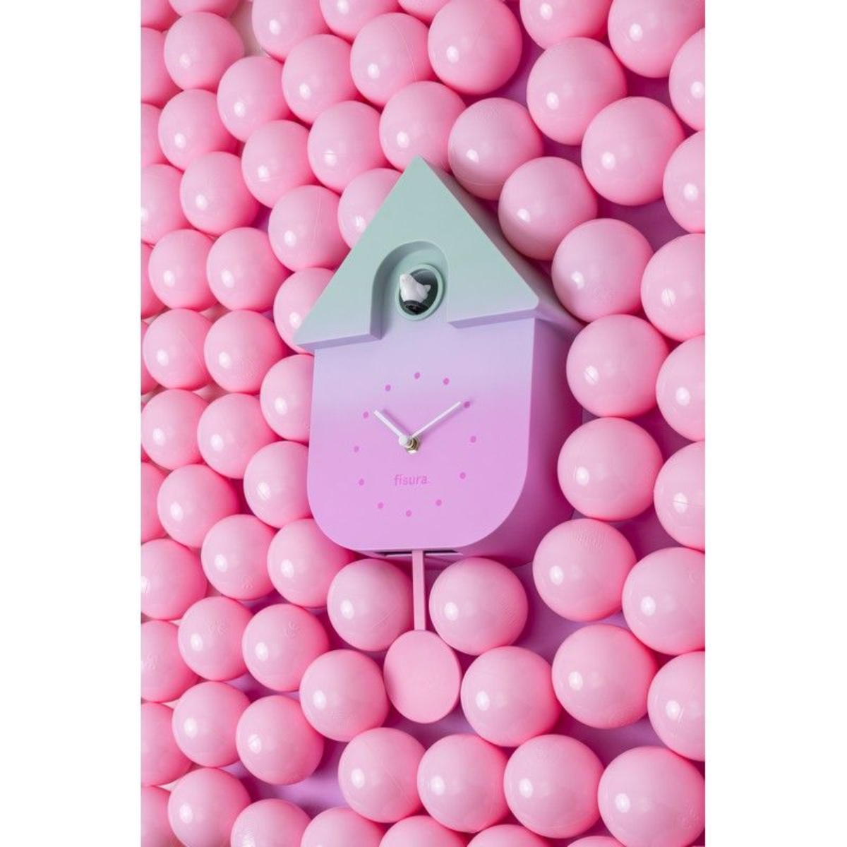 Un orologio a cucù su un muro coperto di palline rosa.