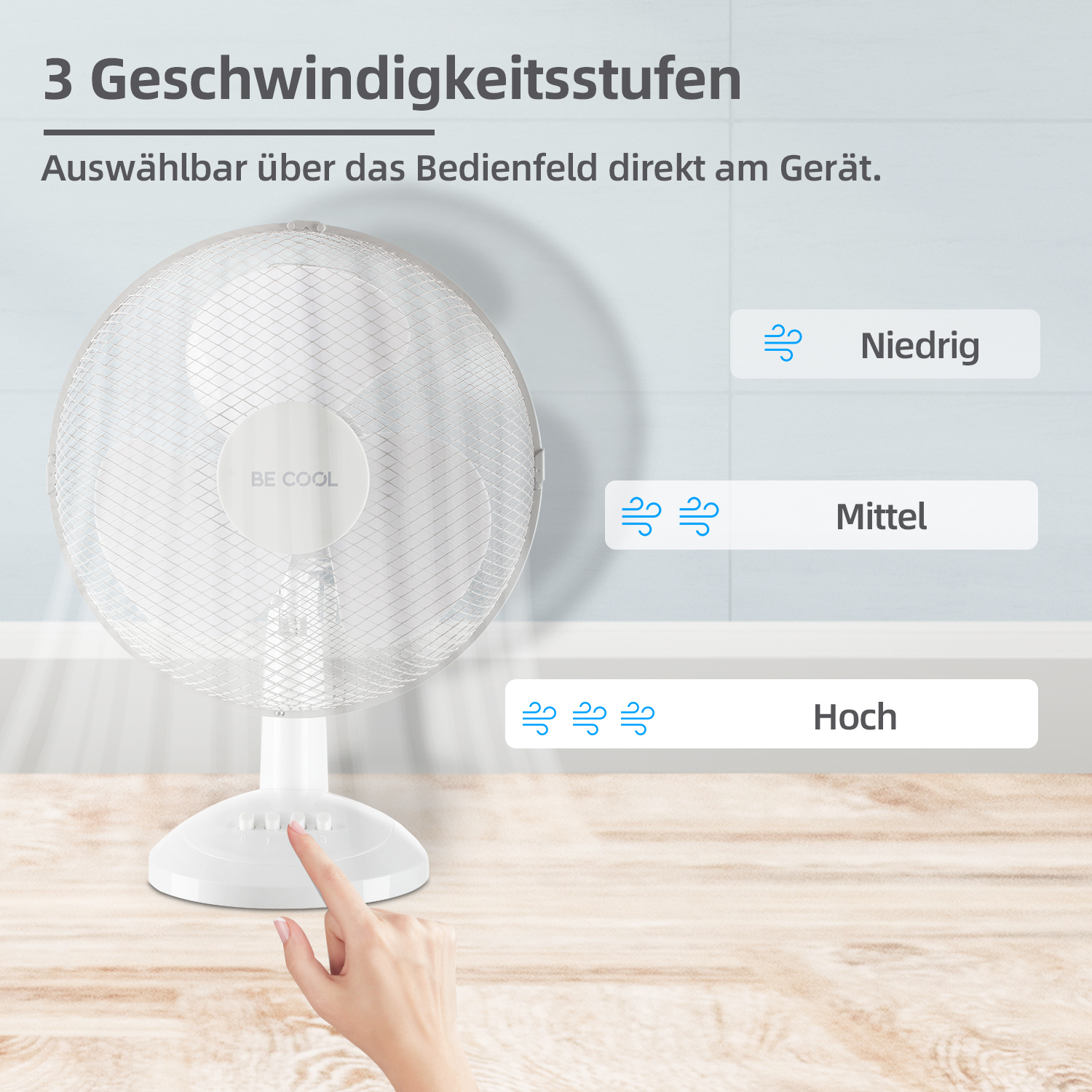 Ein weißer Ventilator mit drei Geschwindigkeitseinstellungen. Eine Hand stellt die Geschwindigkeit ein.