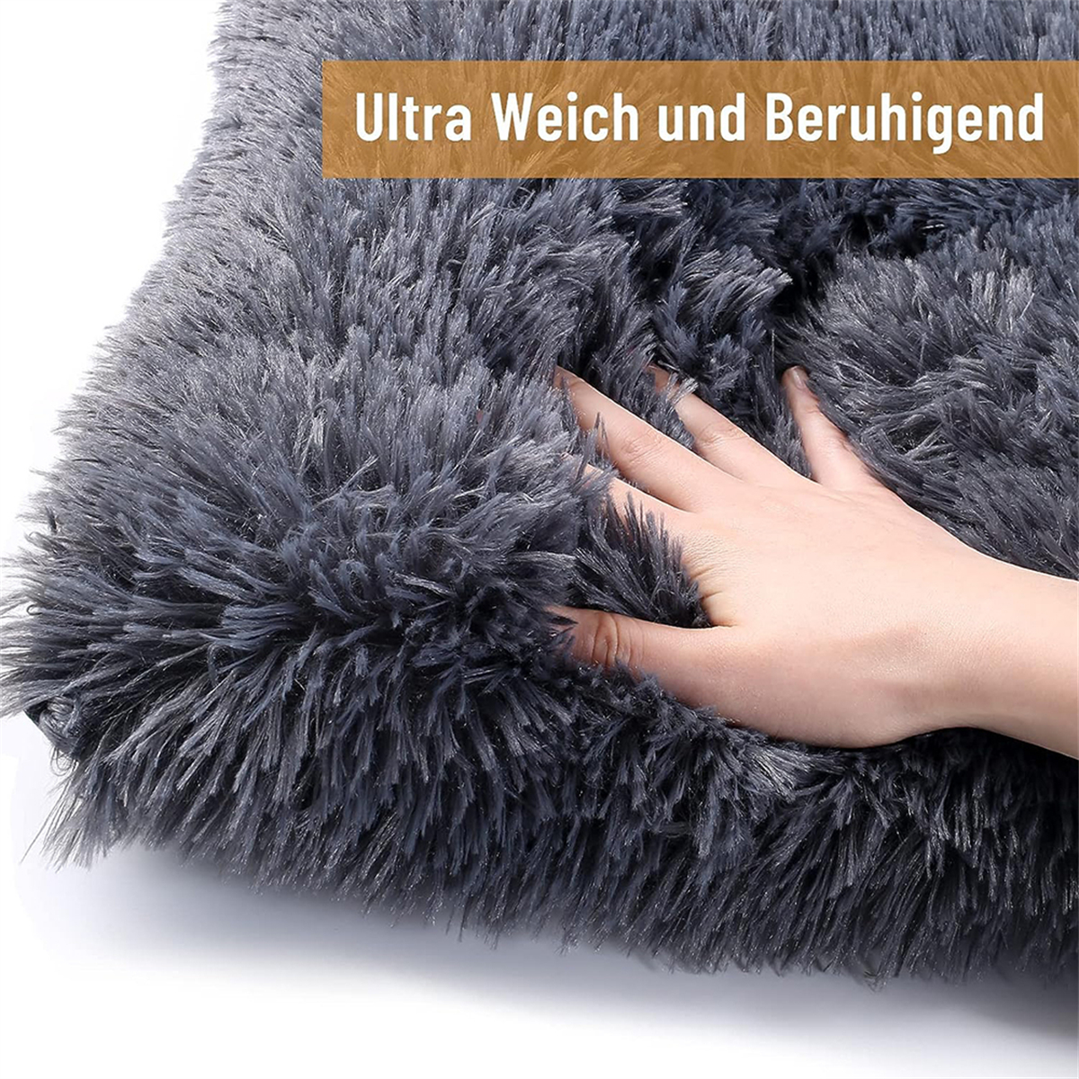 Ein graues, flauschiges Hundebett mit einer Hand, die die Oberfläche berührt.