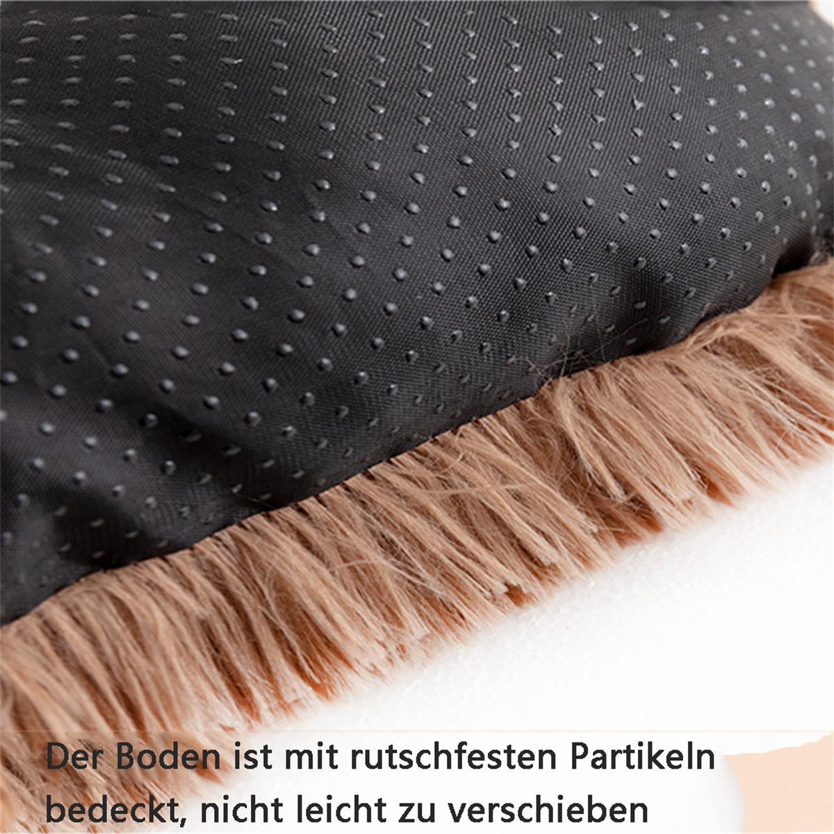 Nahaufnahme eines Hundebetts, der Boden ist schwarz mit Gummipartikeln, die Oberseite ist braunes Fell.