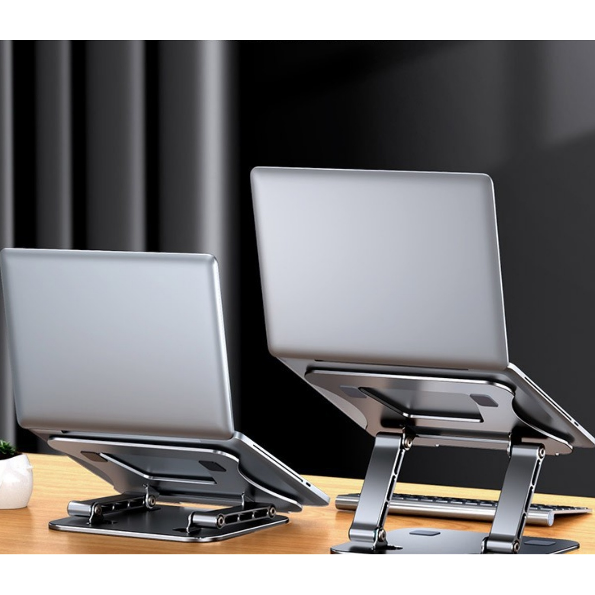 Zwei Laptops auf silbernen Laptopständern. Schwarzer Hintergrund. Laptops sind geöffnet.