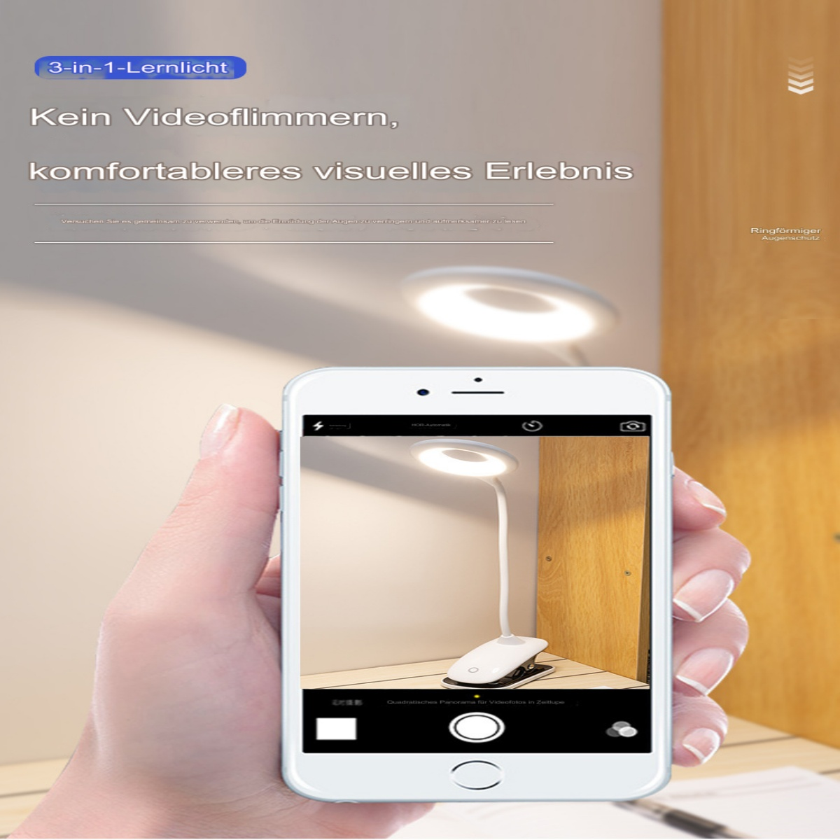 Eine Hand, die ein Telefon hält, das eine Schreibtischlampe zeigt. Die Lampe ist weiß und hat ein kreisförmiges Licht und einen Clip.
