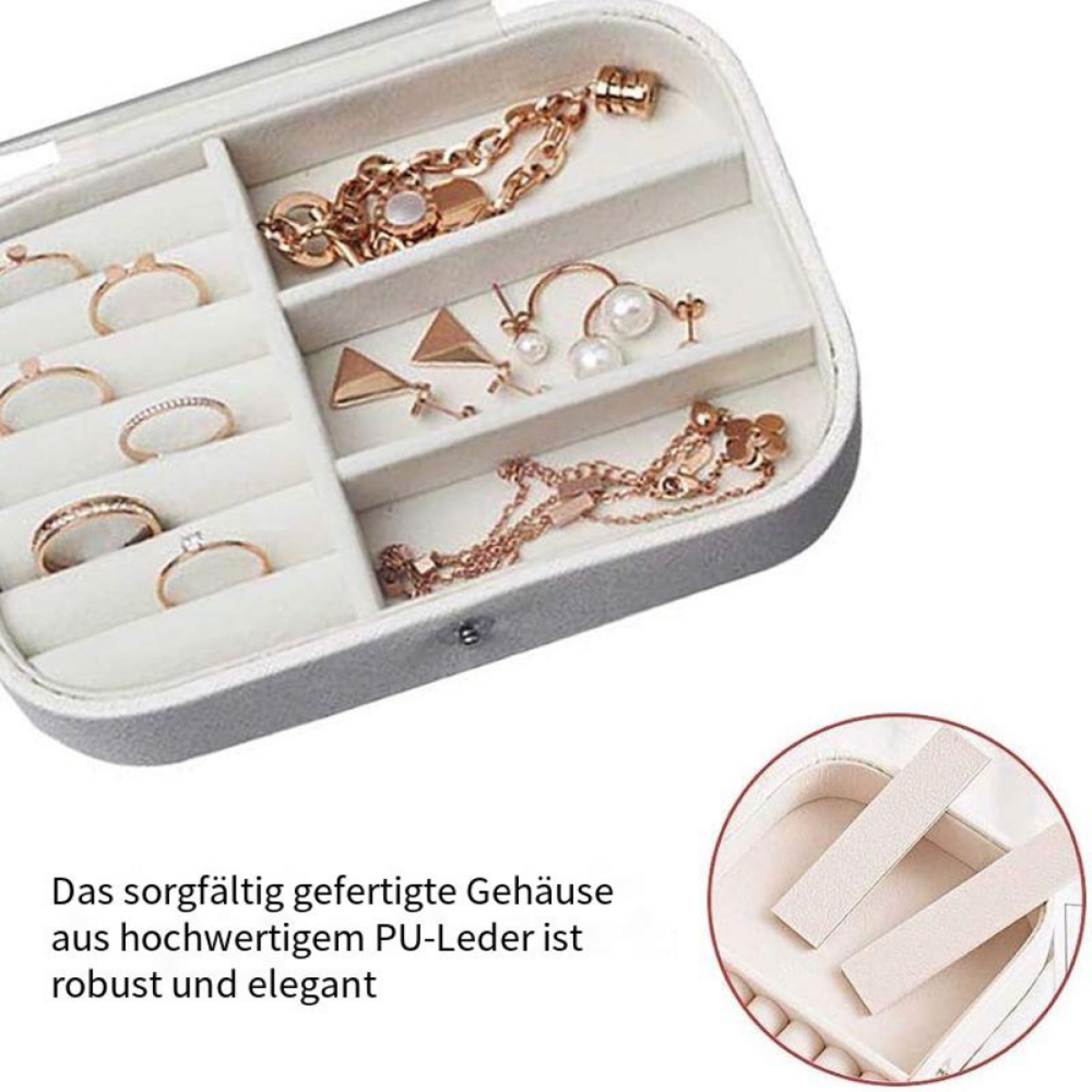 Offene Schmuckschatulle mit Ringen und Halsketten. Schatulle ist grau mit weißem Innenraum und Goldschmuck.