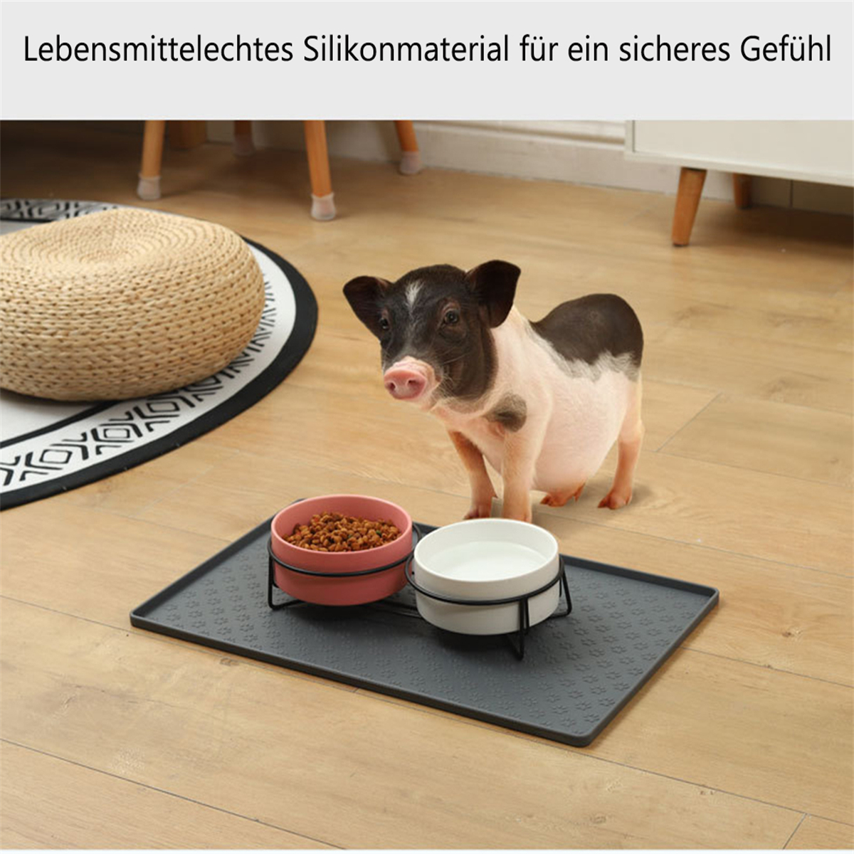 Ein kleines Schwein steht in der Nähe von zwei Schalen auf einem Tablett. Text: 'Lebensmittelechtes Silikonmaterial für ein sicheres Gefühl'.
