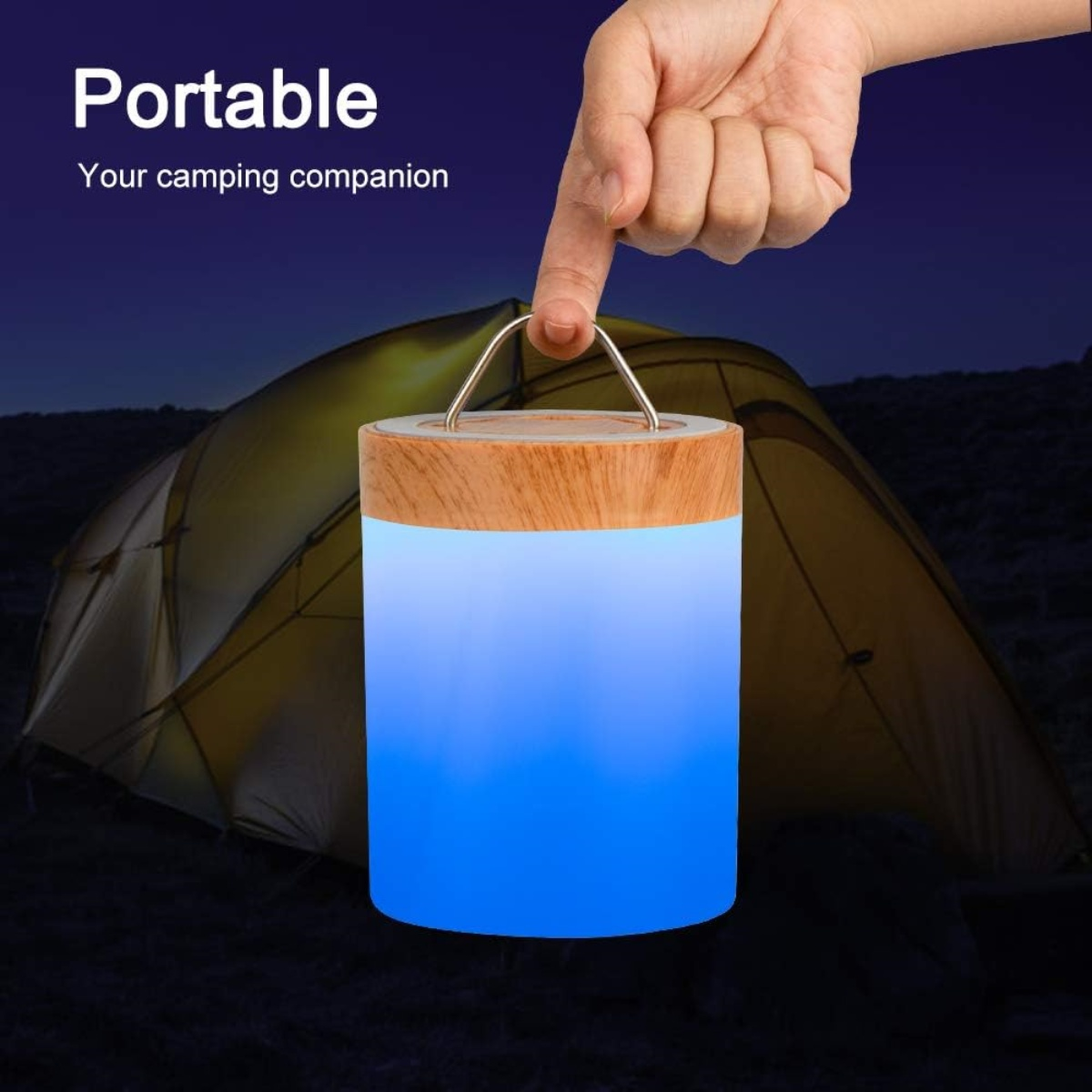Eine tragbare Laterne mit Holzaufsatz und blauem Licht, gehalten von einer Hand vor einer dunklen Camping-Szene.