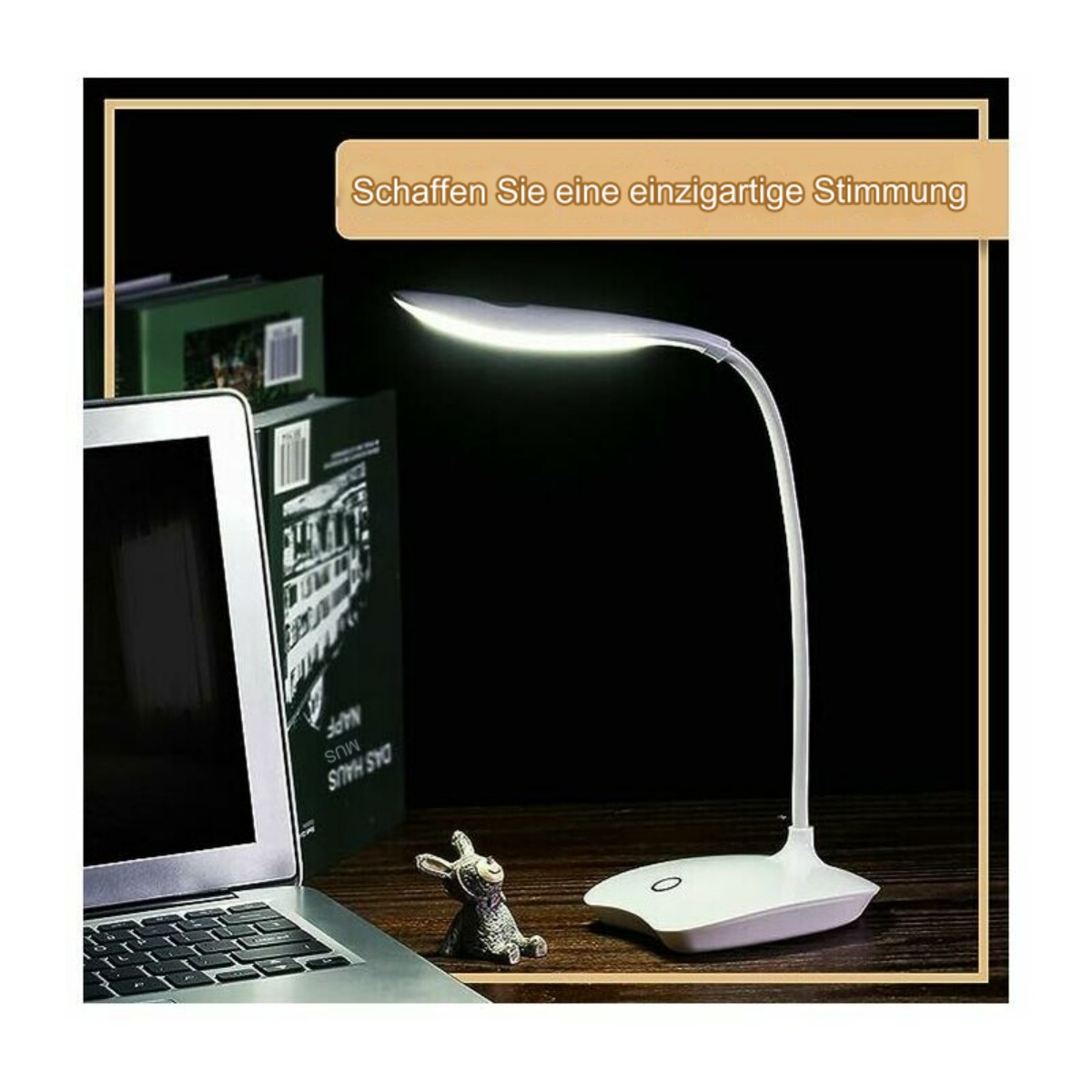 Weiße Schreibtischlampe auf einem Schreibtisch mit Laptop, Hasenfigur und Büchern. Sie hat einen warmen Schein. Dunkler Hintergrund.