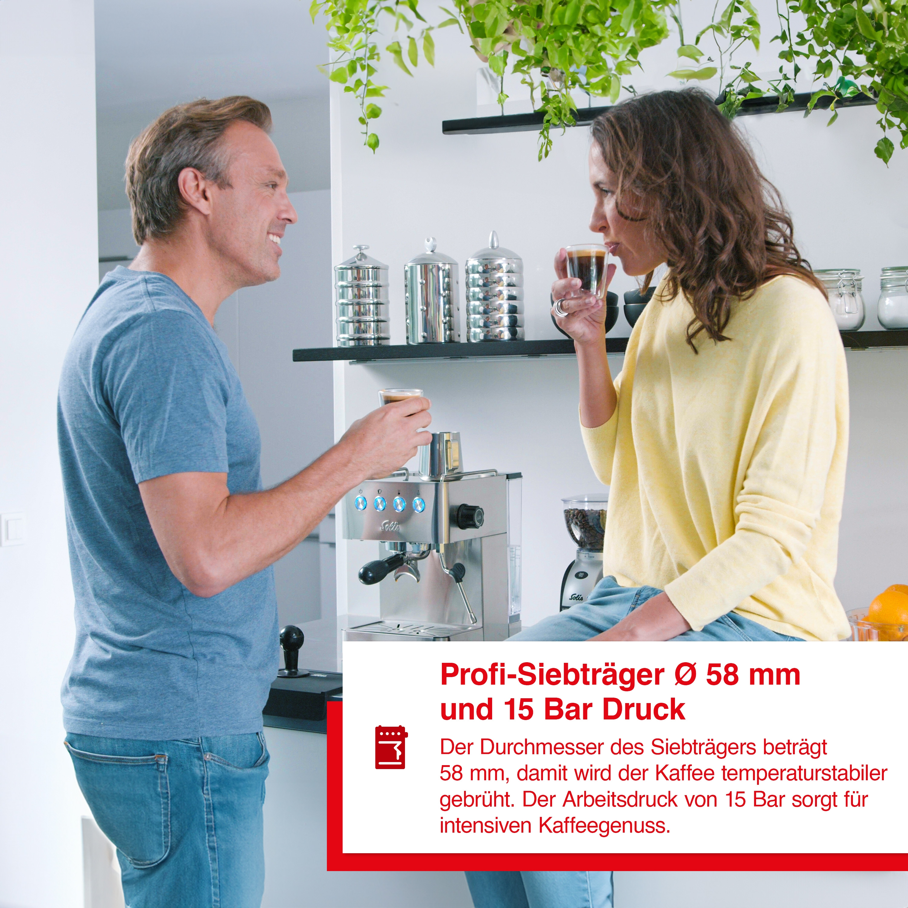 Ein Mann und eine Frau trinken Kaffee. Die Kaffeemaschine befindet sich im Hintergrund.