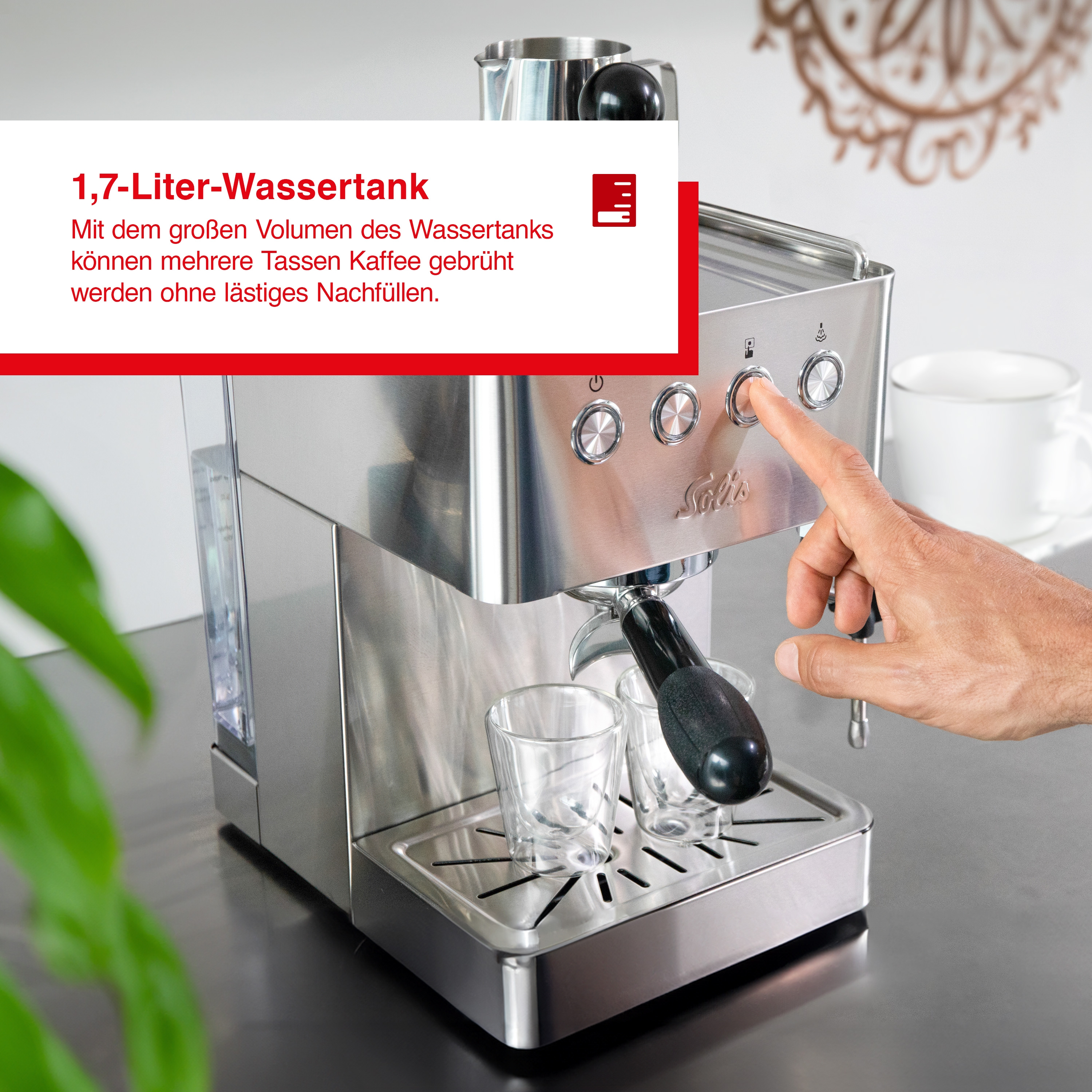 Silberne Espressomaschine mit Wassertank und eine Hand, die einen Knopf drückt.
