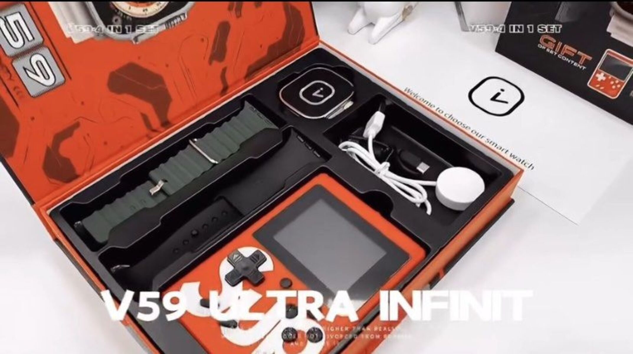 Una caja de regalo abierta con un reloj inteligente, una consola de juegos, componentes de carga y correas. La caja es roja y negra.
