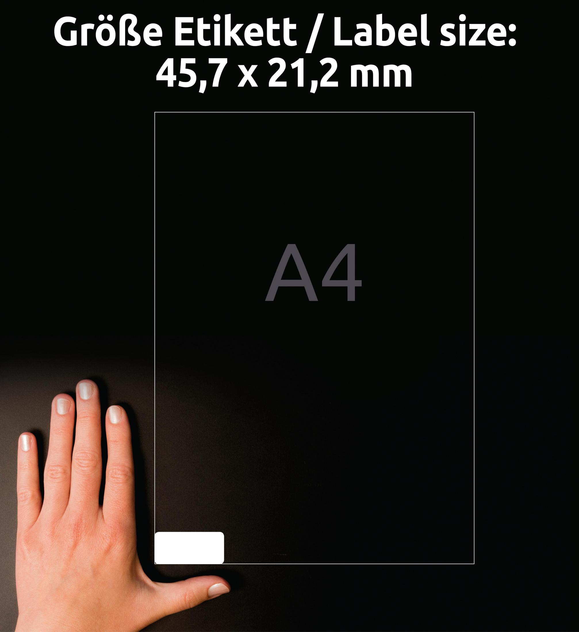 A4-Papier mit Hand und Text auf Deutsch. Das Papier liegt auf schwarzem Grund mit weißem Etikett.