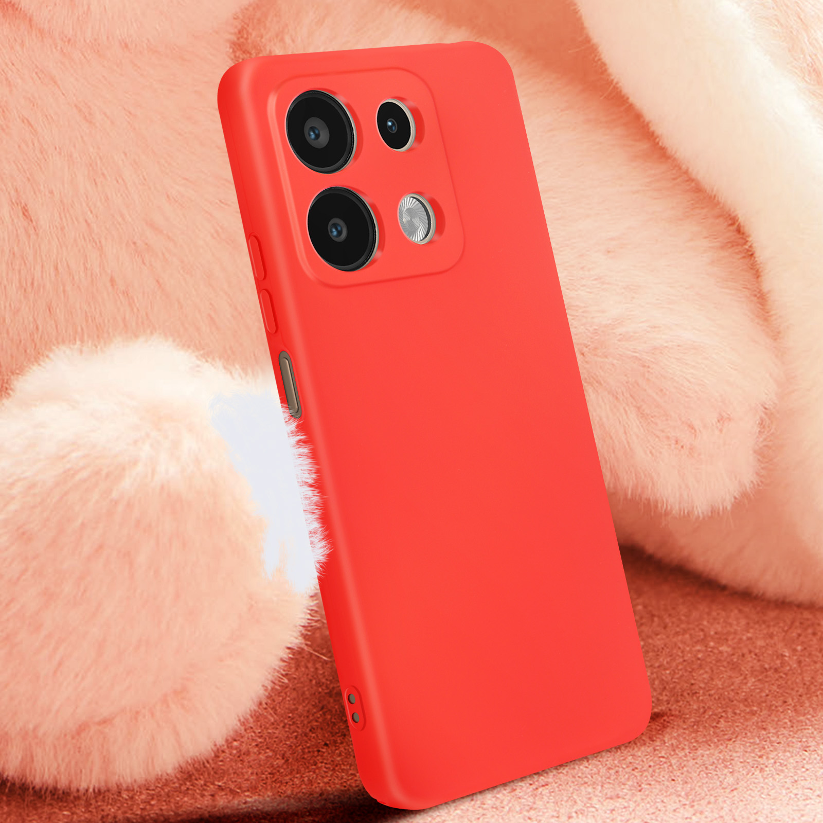 Custodia per telefono rossa su uno sfondo rosa e soffice, con la fotocamera visibile.