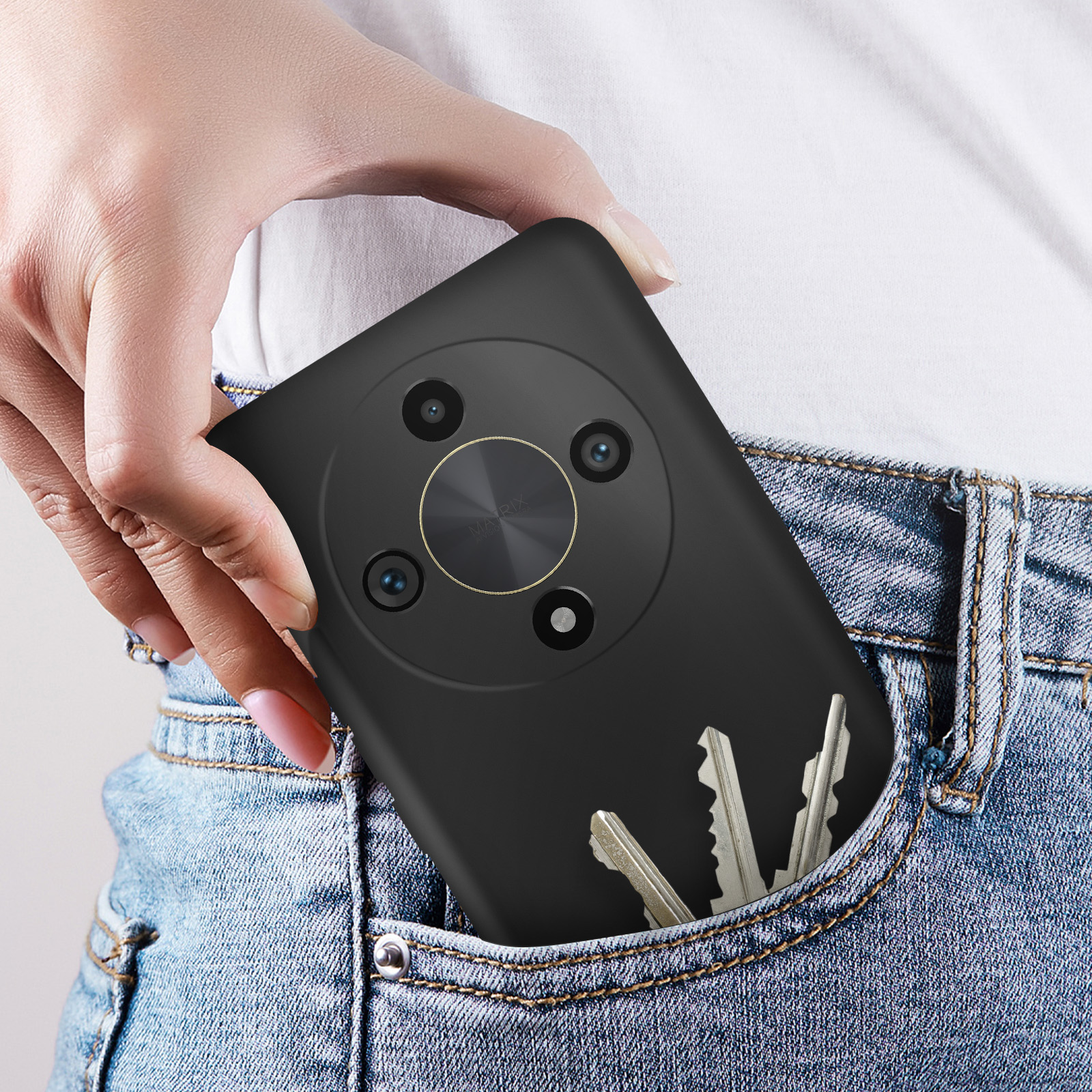 Una mano in tasca dei jeans tiene un telefono nero con fotocamera circolare e chiavi.
