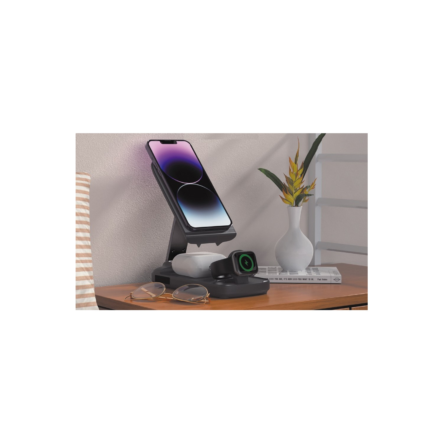 Ladestation mit Handy, Uhr, Ohrhörern und Sonnenbrille auf Tisch.