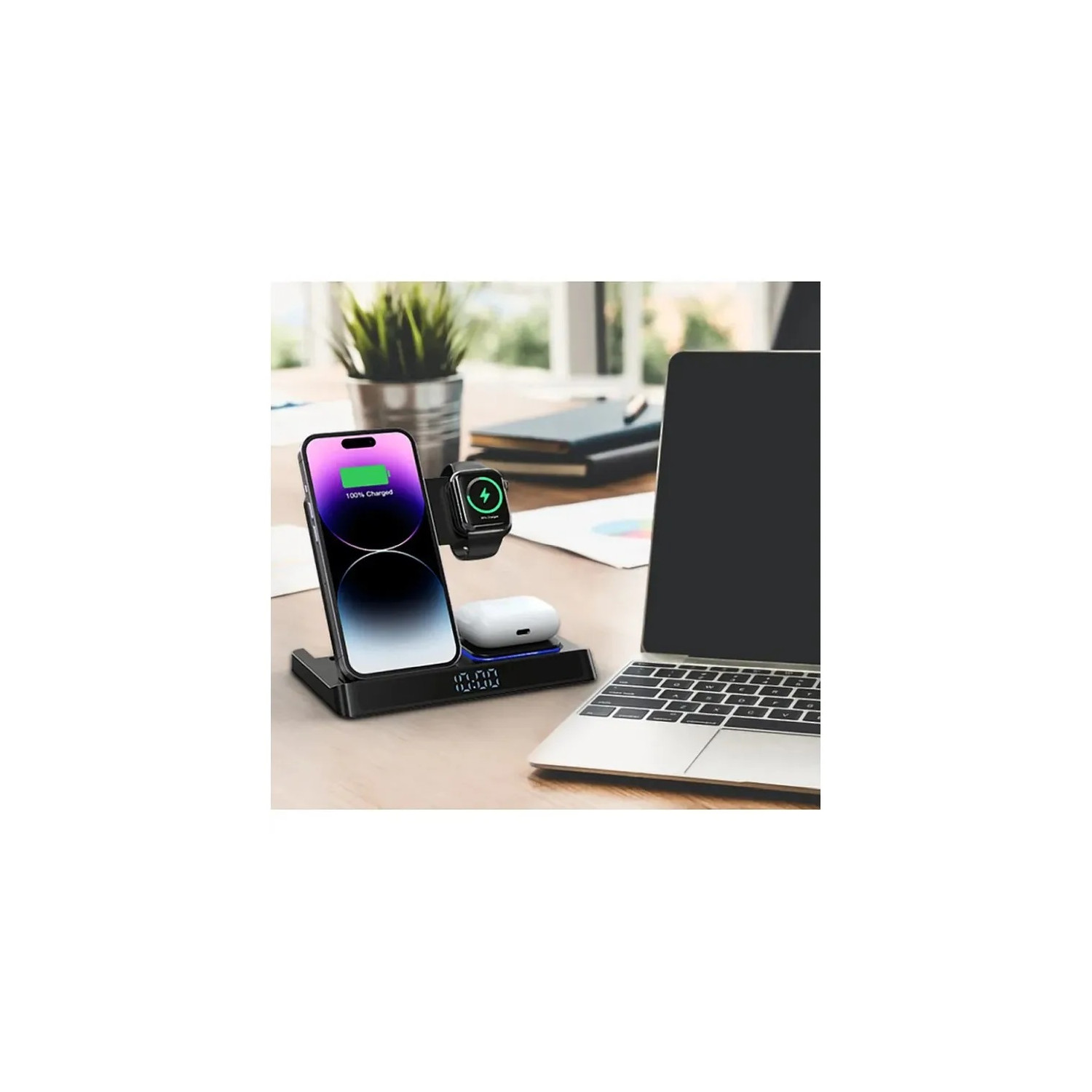Schwarze kabellose Ladestation mit Telefon, Uhr und Ohrhörern. Laptop und Pflanze sichtbar.