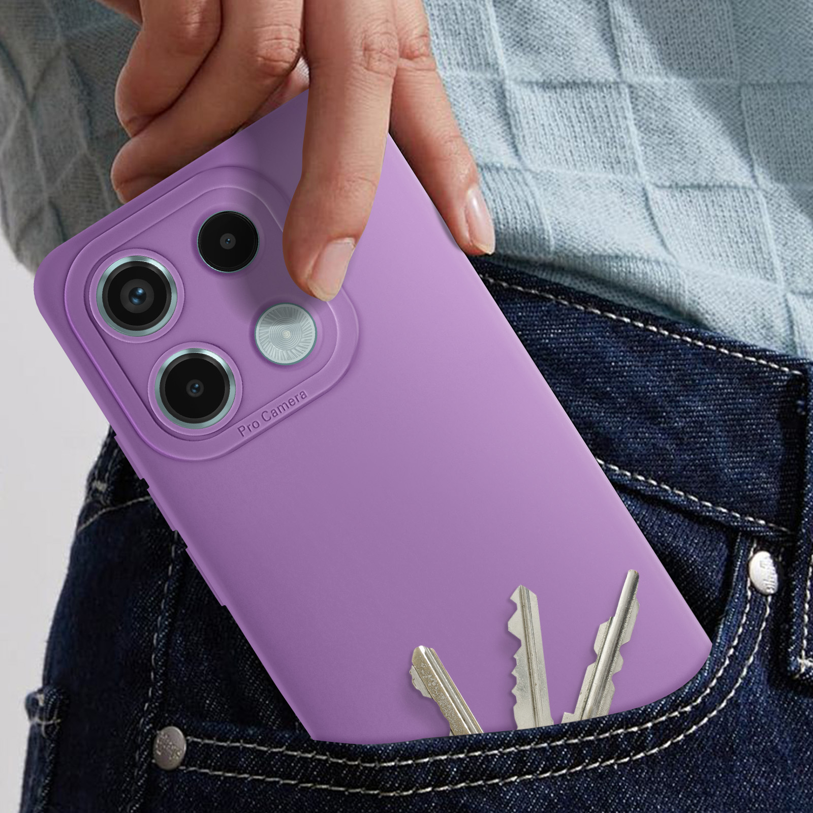 Una mano che tiene un telefono viola in una tasca di jeans con chiavi.