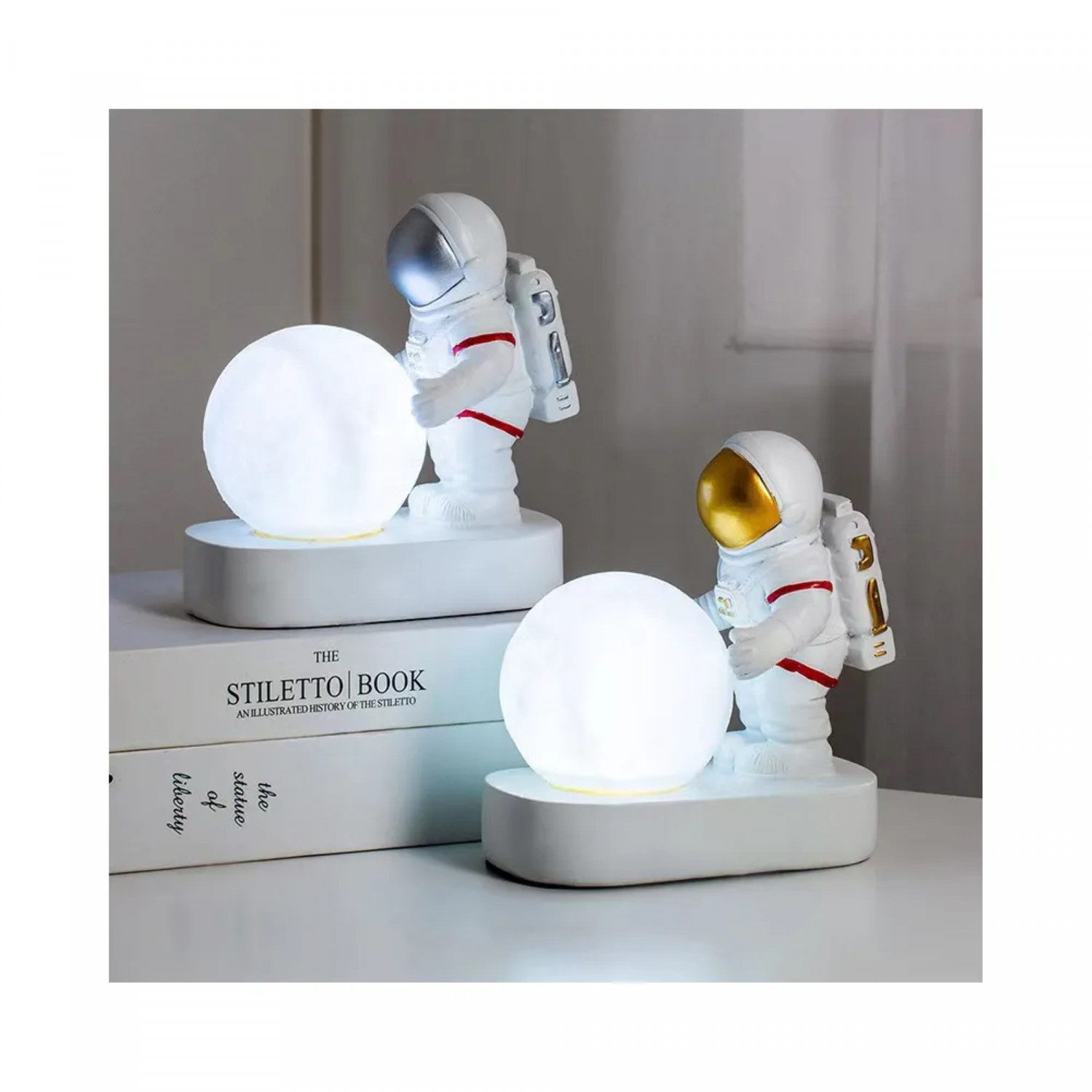 Zwei Astronautenlampen, die weiße, leuchtende Kugeln halten, auf weißer Oberfläche.