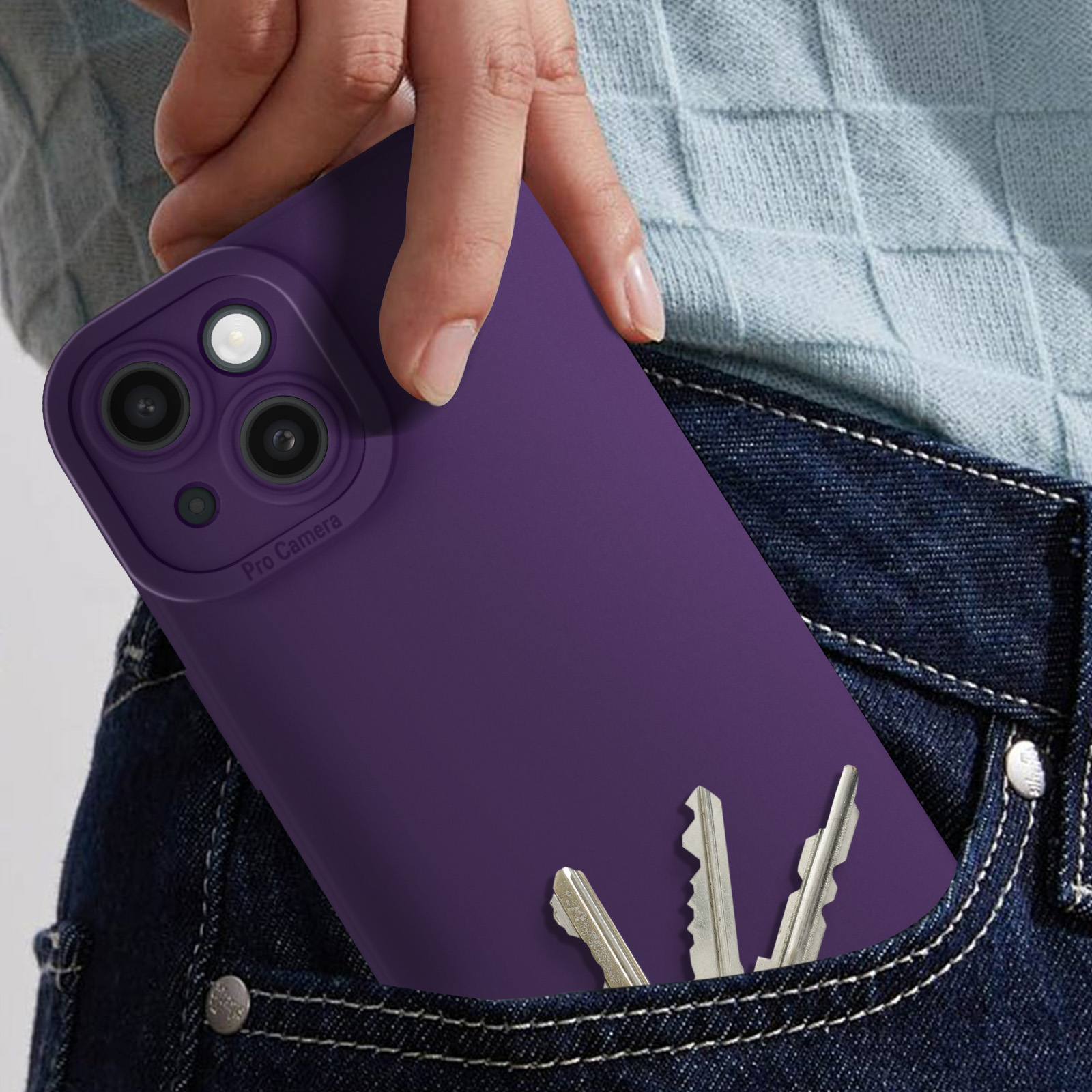 La mano di una persona che tiene una custodia per telefono viola in una tasca dei jeans con delle chiavi.