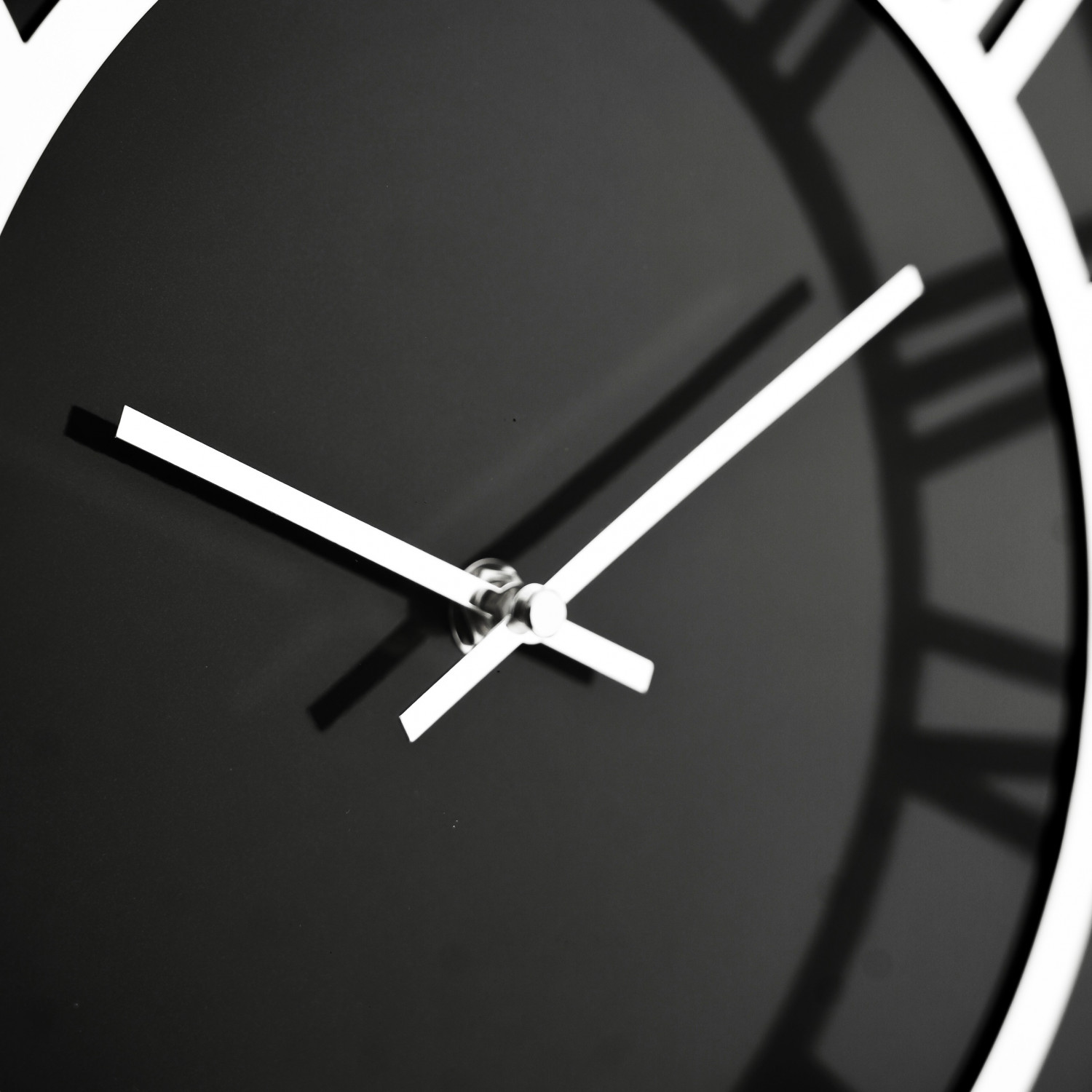 Nahaufnahme eines Zifferblatts mit Zeigern, die auf die Uhrzeit zeigen. Die Uhr ist schwarz mit weißen Zeigern und Zahlen.
