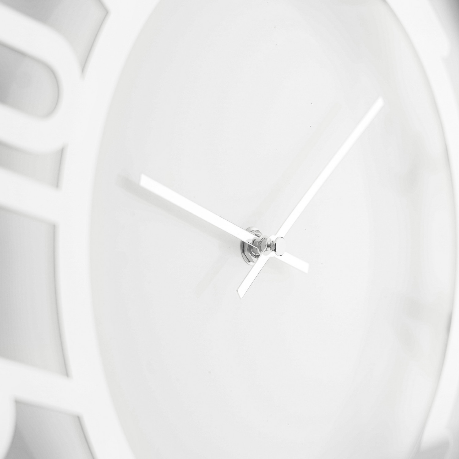 Eine weiße Wanduhr mit schlanken silbernen Zeigern und minimalistischem Design. Die Zeiger zeigen auf etwa 2:10 Uhr.