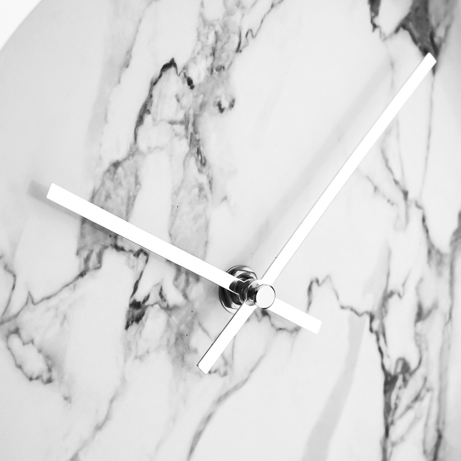 Eine Uhr auf einer Marmoroberfläche mit drei silbernen Zeigern, von denen zwei auf die Zeit weisen.