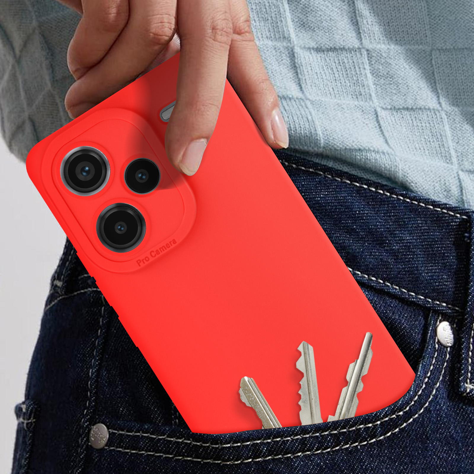 Mano che tiene una custodia rossa con telefono in tasca jeans con chiavi.