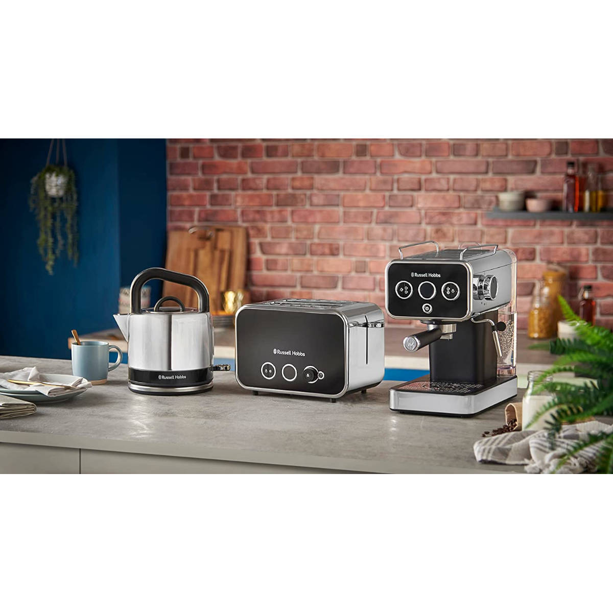 Eine Küchenzeile mit Russell Hobbs-Geräten, darunter ein Wasserkocher, Toaster und Kaffeemaschine.